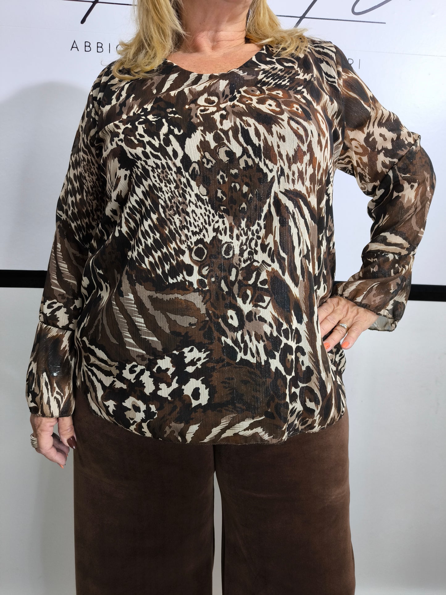 Blusa con stampa animalier mista, indossata da una donna per un look jungle chic.