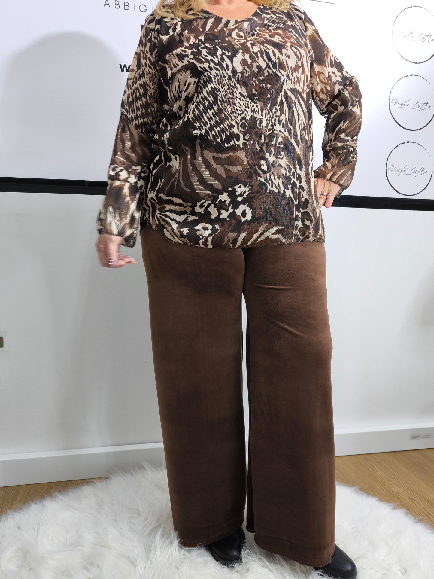 Blusa con stampa animalier mista, indossata da una donna per un look jungle chic.