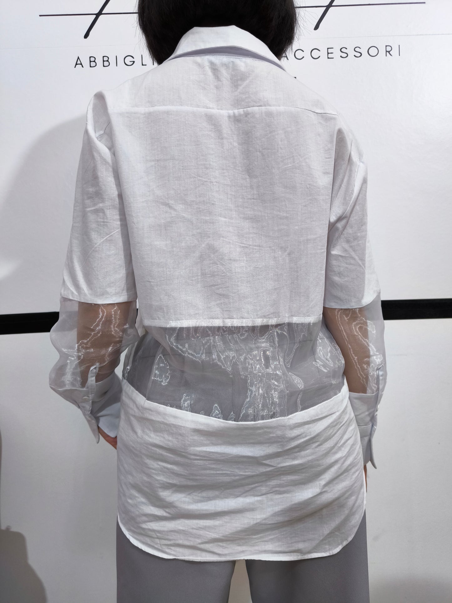 Camicia bianca con pannelli trasparenti in tulle, perfetta per un look moderno e femminile, con maniche lunghe e design elegante.