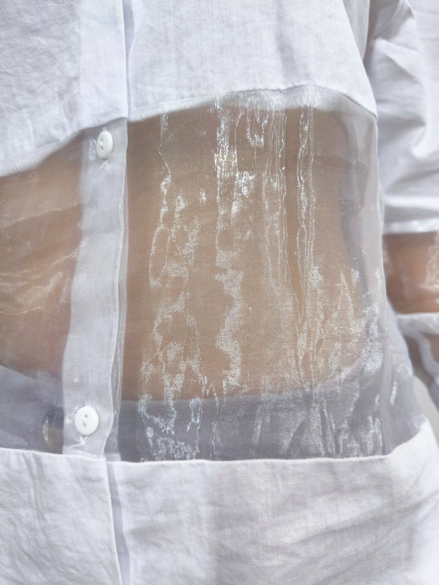 Camicia bianca con pannelli trasparenti in tulle, perfetta per un look moderno e femminile, con maniche lunghe e design elegante.
