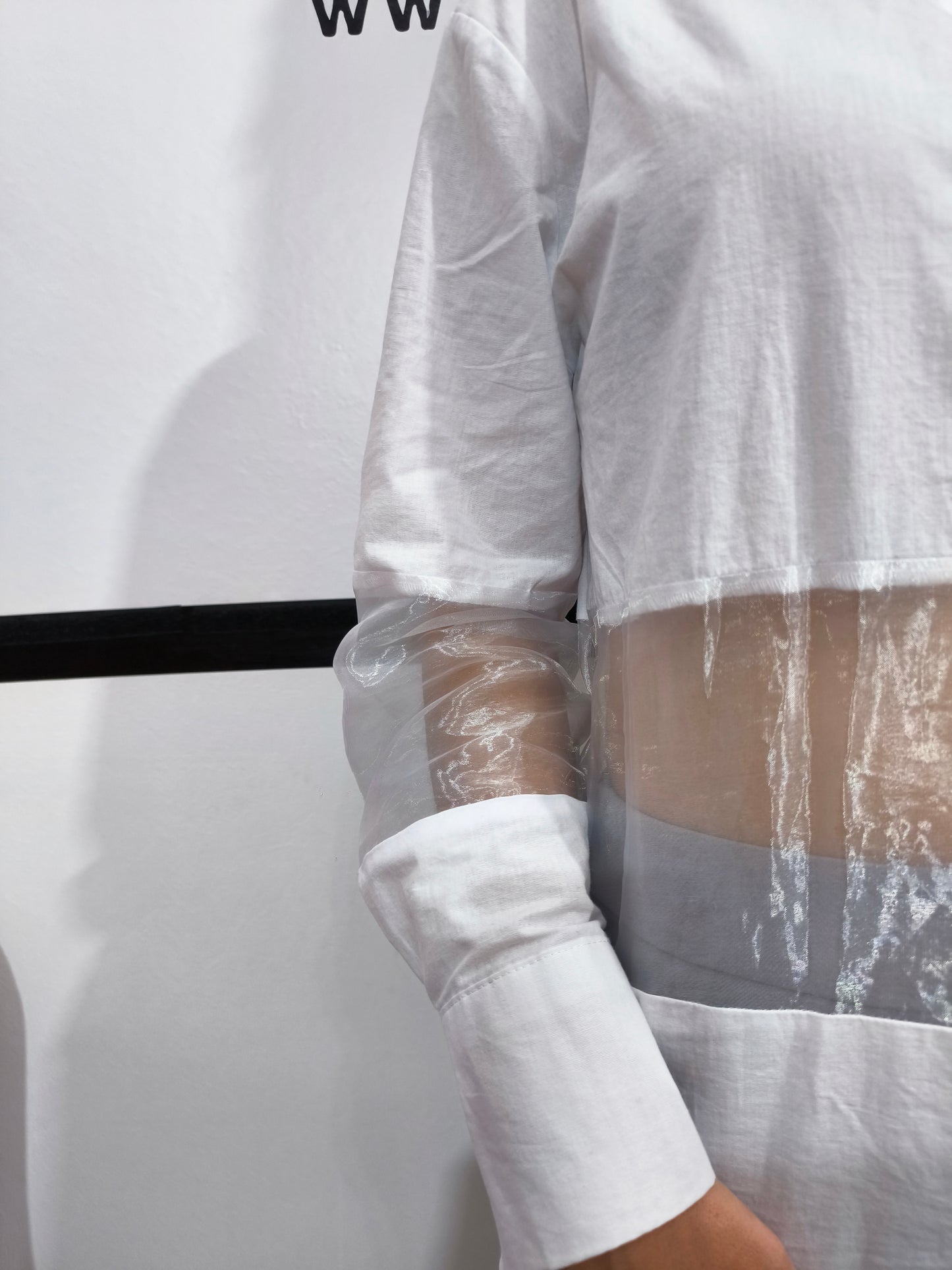 Camicia bianca con pannelli trasparenti in tulle, perfetta per un look moderno e femminile, con maniche lunghe e design elegante.