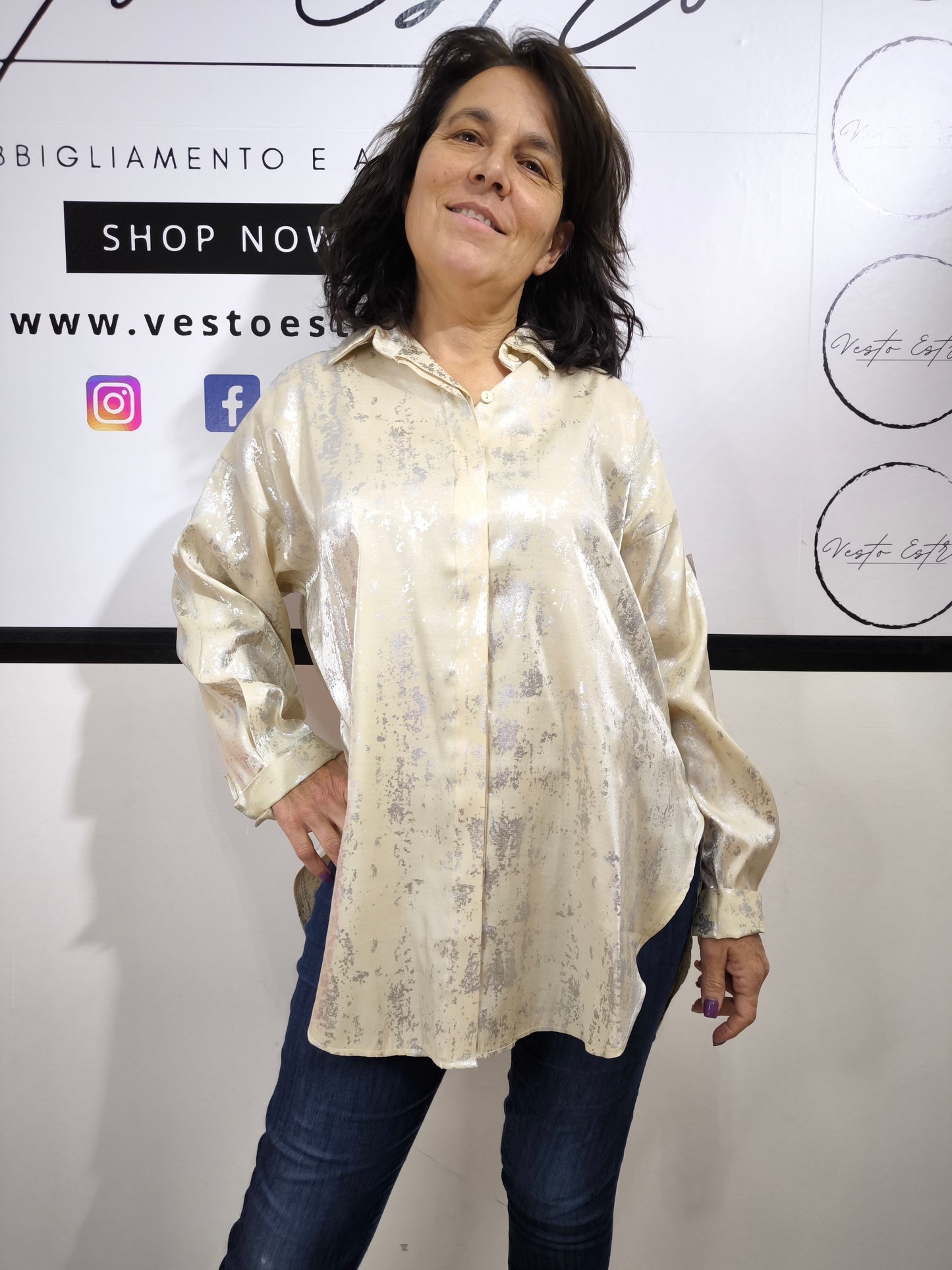 Camicia oversize da donna crema con stampa astratta dorata, indossata con jeans. Look moderno ed elegante.
