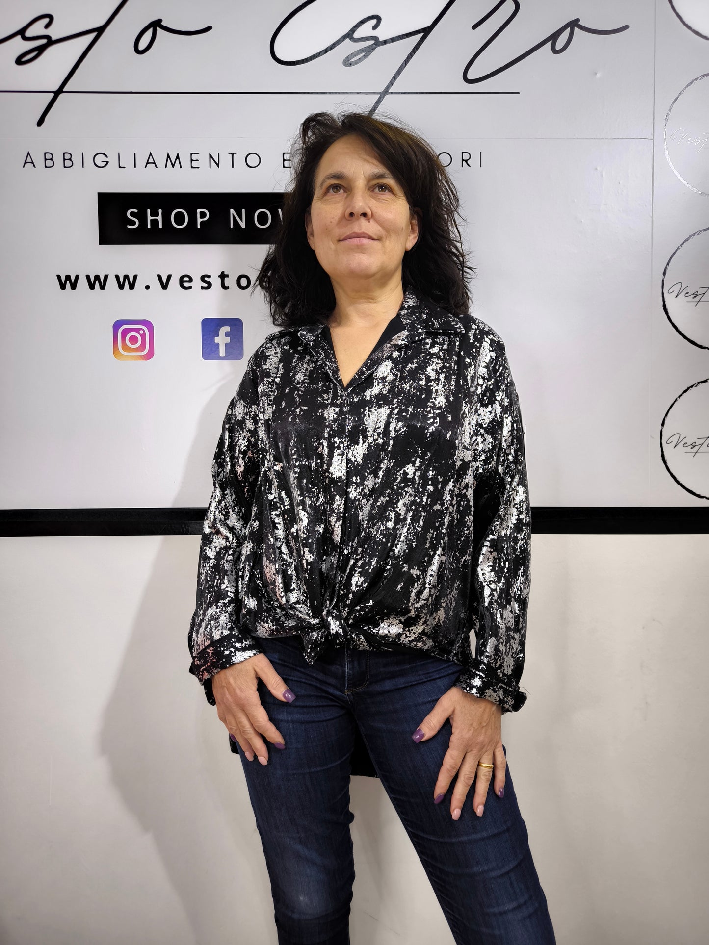 Camicia oversize da donna nera con stampa astratta argentata, indossata con jeans. Look moderno ed elegante.