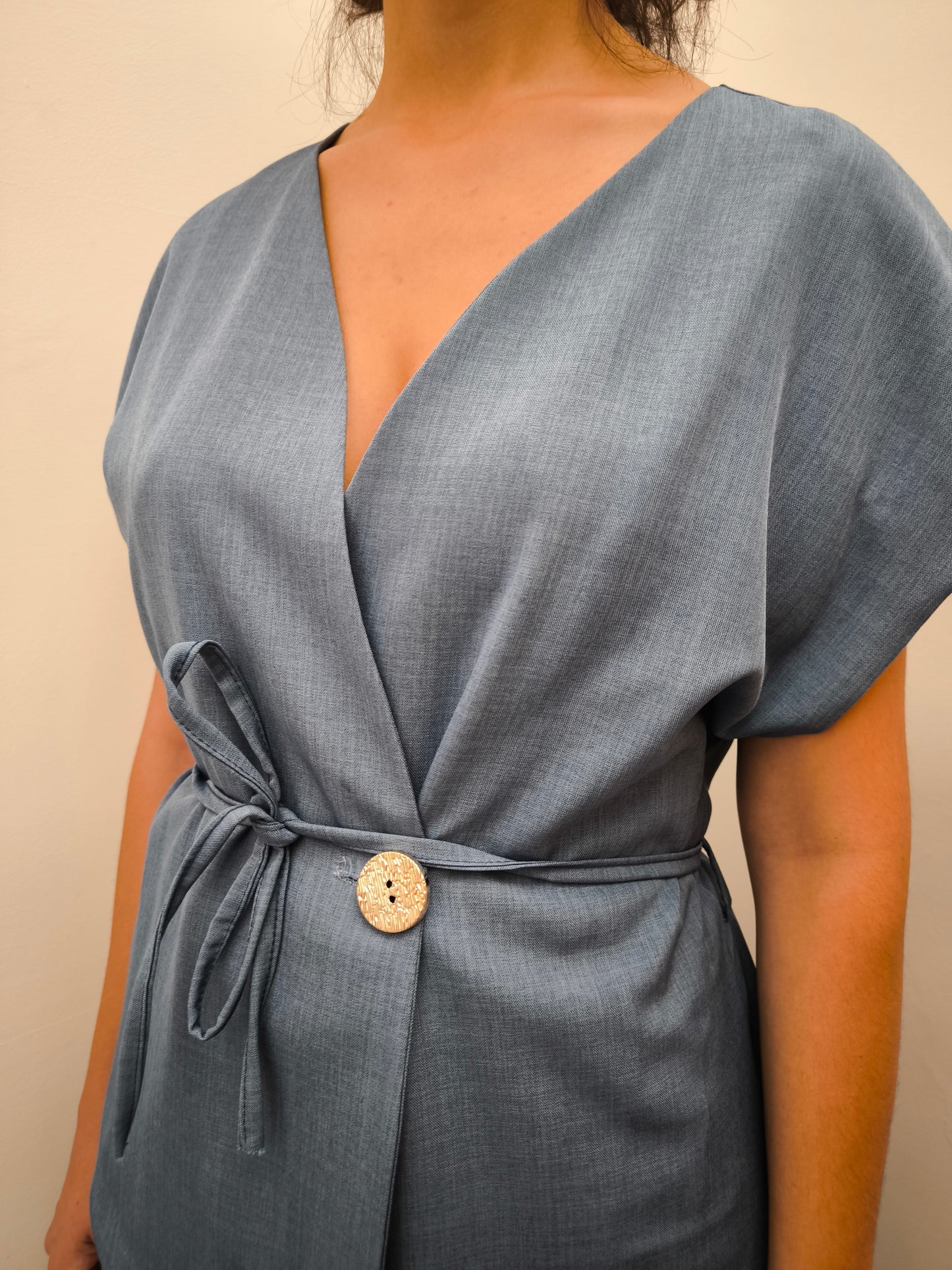 Donna che indossa completo elegante AURA in tessuto denim, con giacca foderata a manica corta