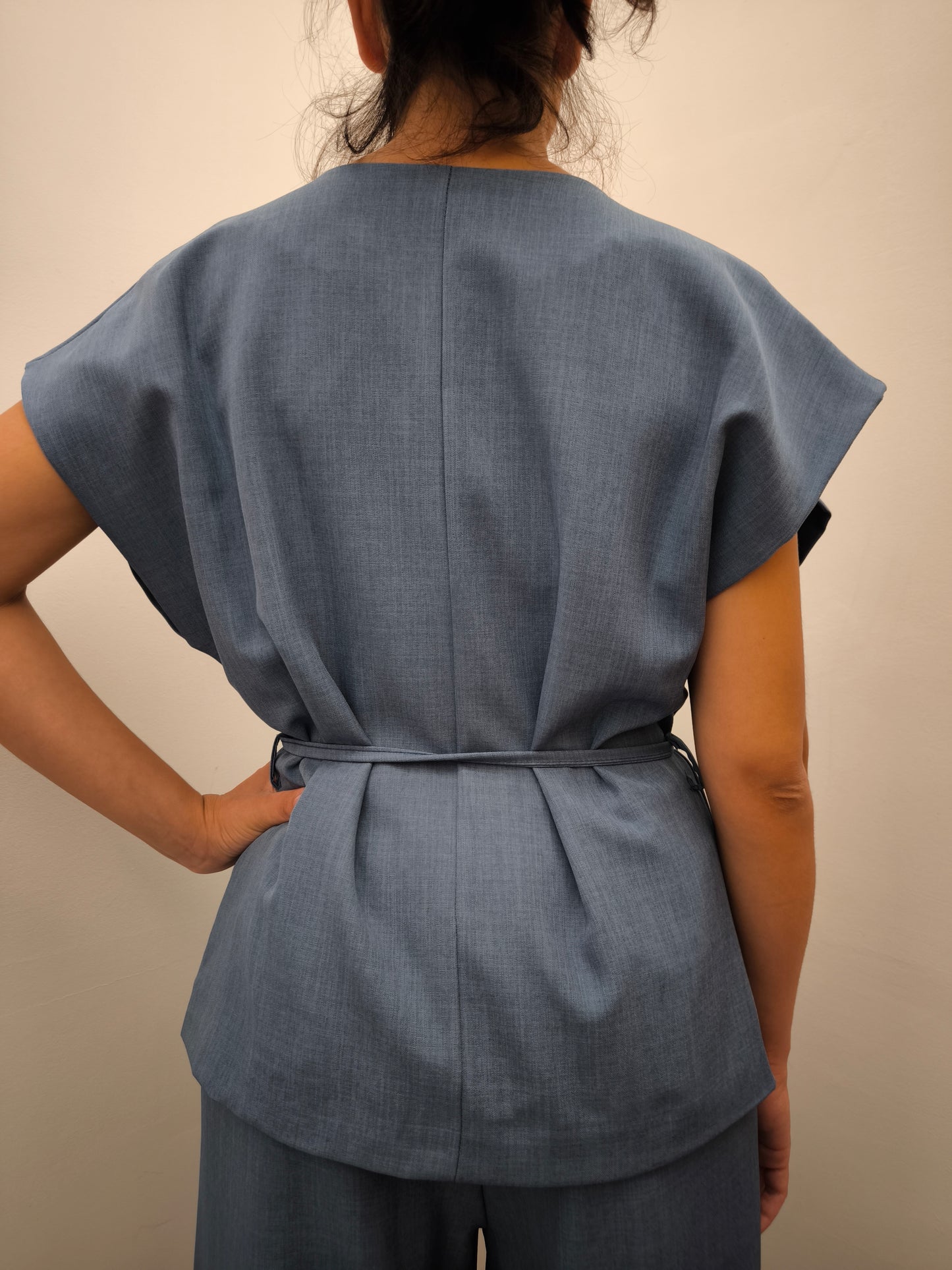 Donna che indossa completo elegante AURA in tessuto denim, con giacca foderata a manica corta