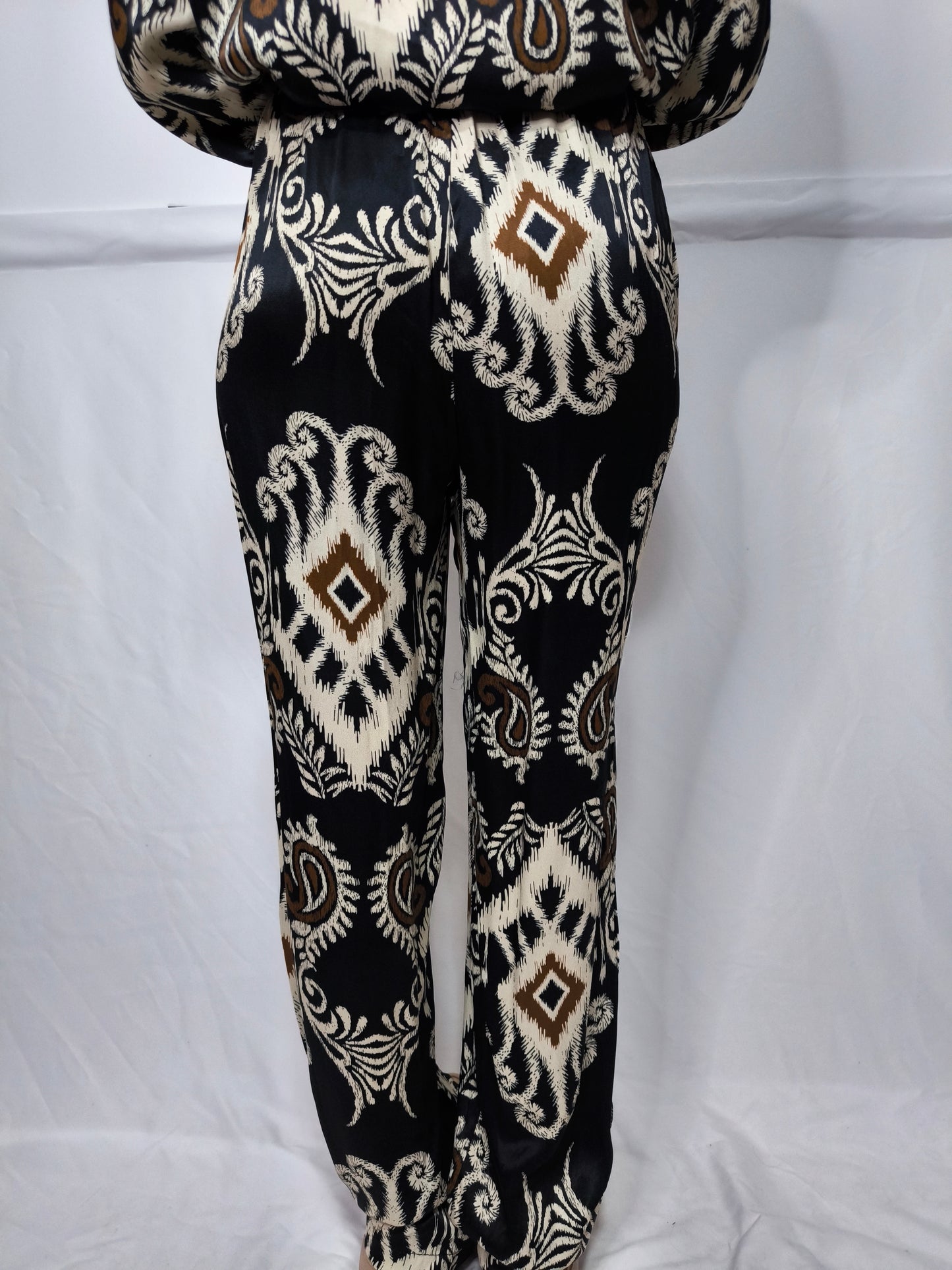 Completo donna fantasia etnica, composto da camicia a maniche lunghe e pantaloni ampi con elastico in vita, realizzato in tessuto morbido e fluido.