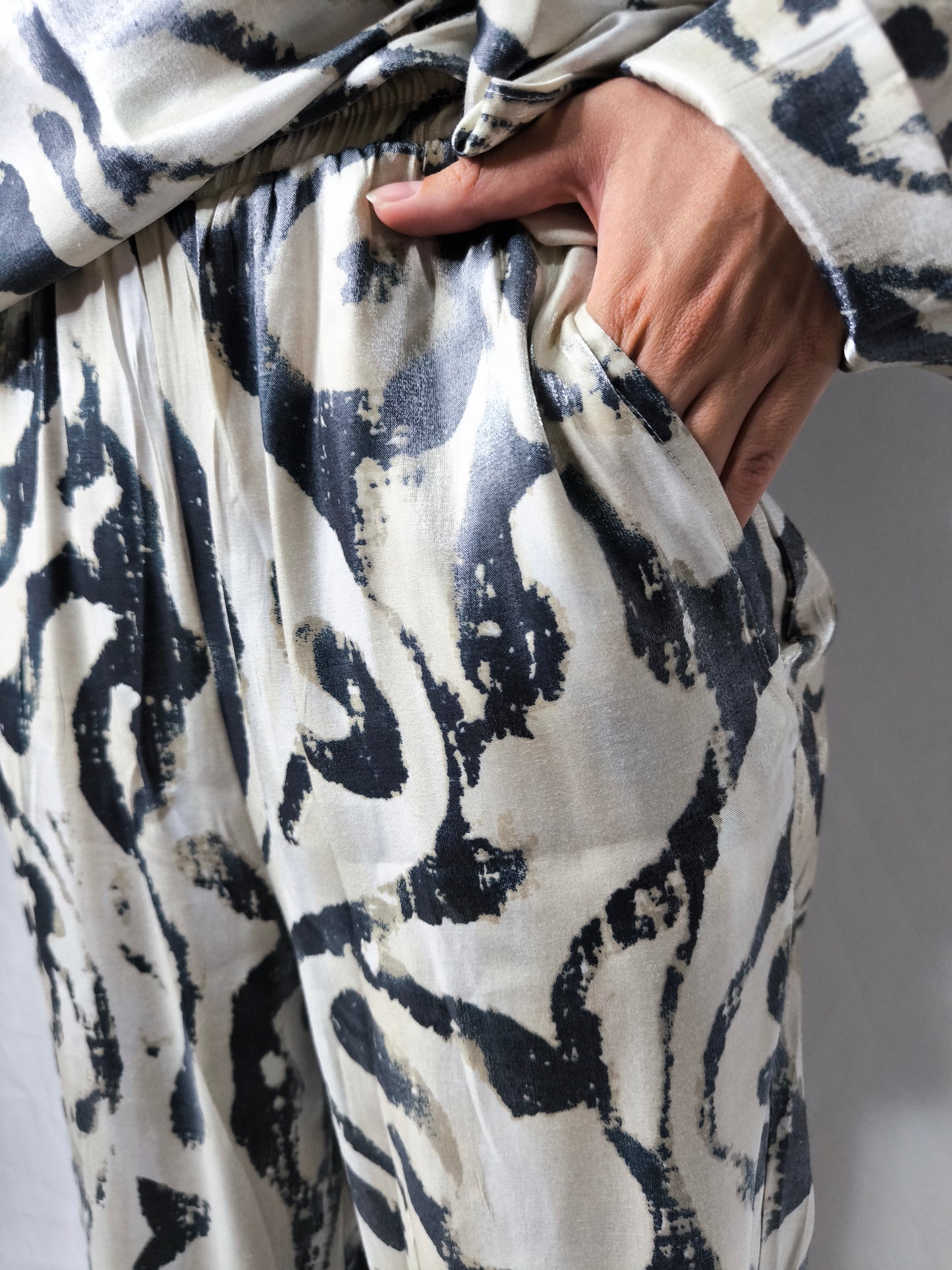 Completo donna con stampa astratta bicolore, composto da camicia a maniche lunghe e pantaloni ampi, ideale per un look moderno e confortevole.