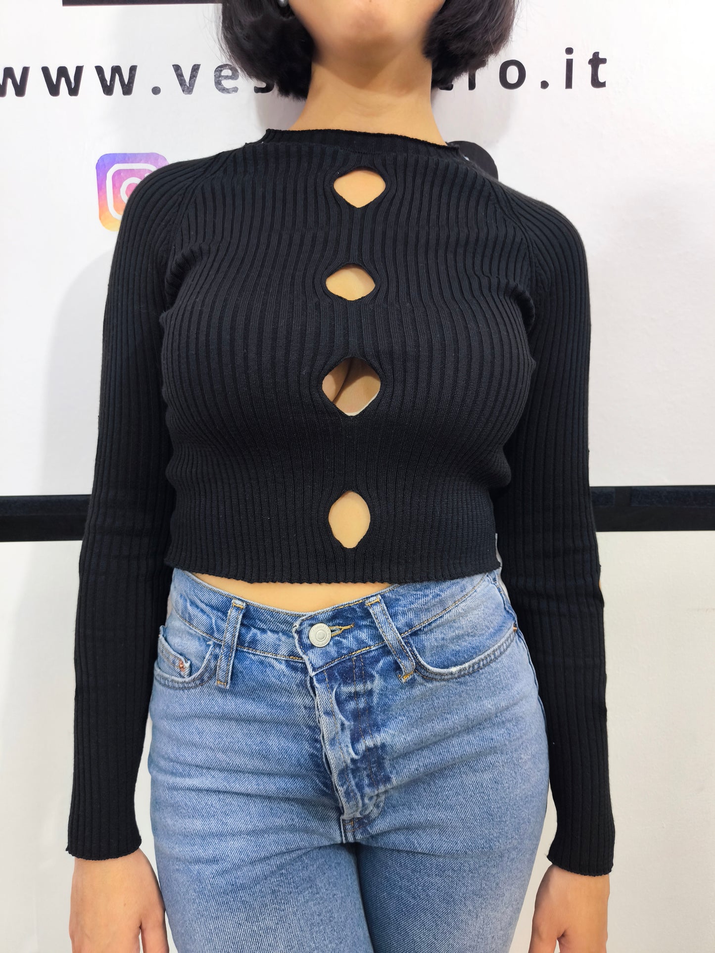 Maglia nera a costine da donna con dettagli cut-out sul davanti.