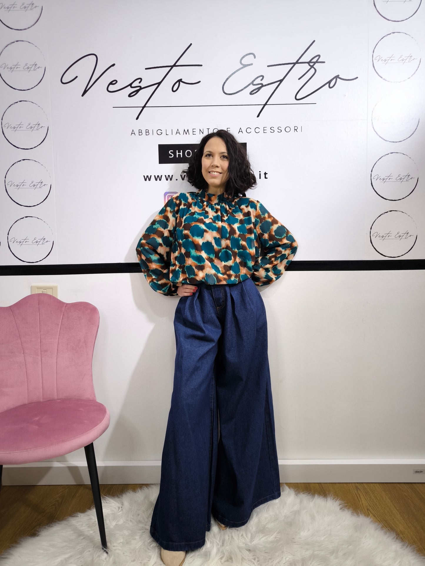 Jeans ampio a vita alta da donna in denim blu, stile palazzo, fotografato su tappeto bianco.