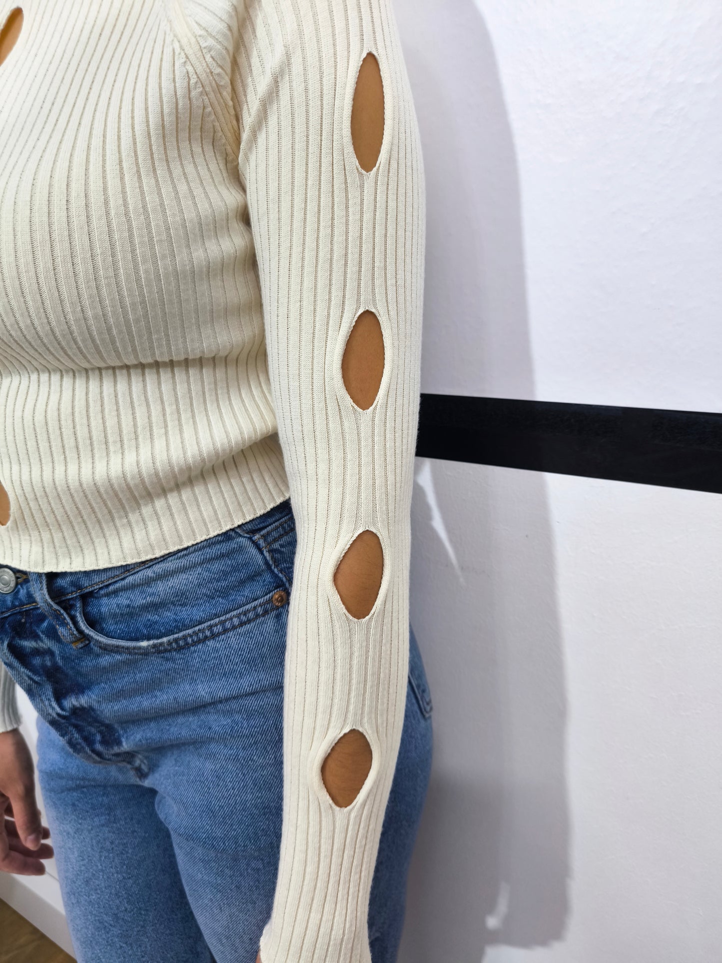 Maglia panna a costine da donna con dettagli cut-out sul davanti.