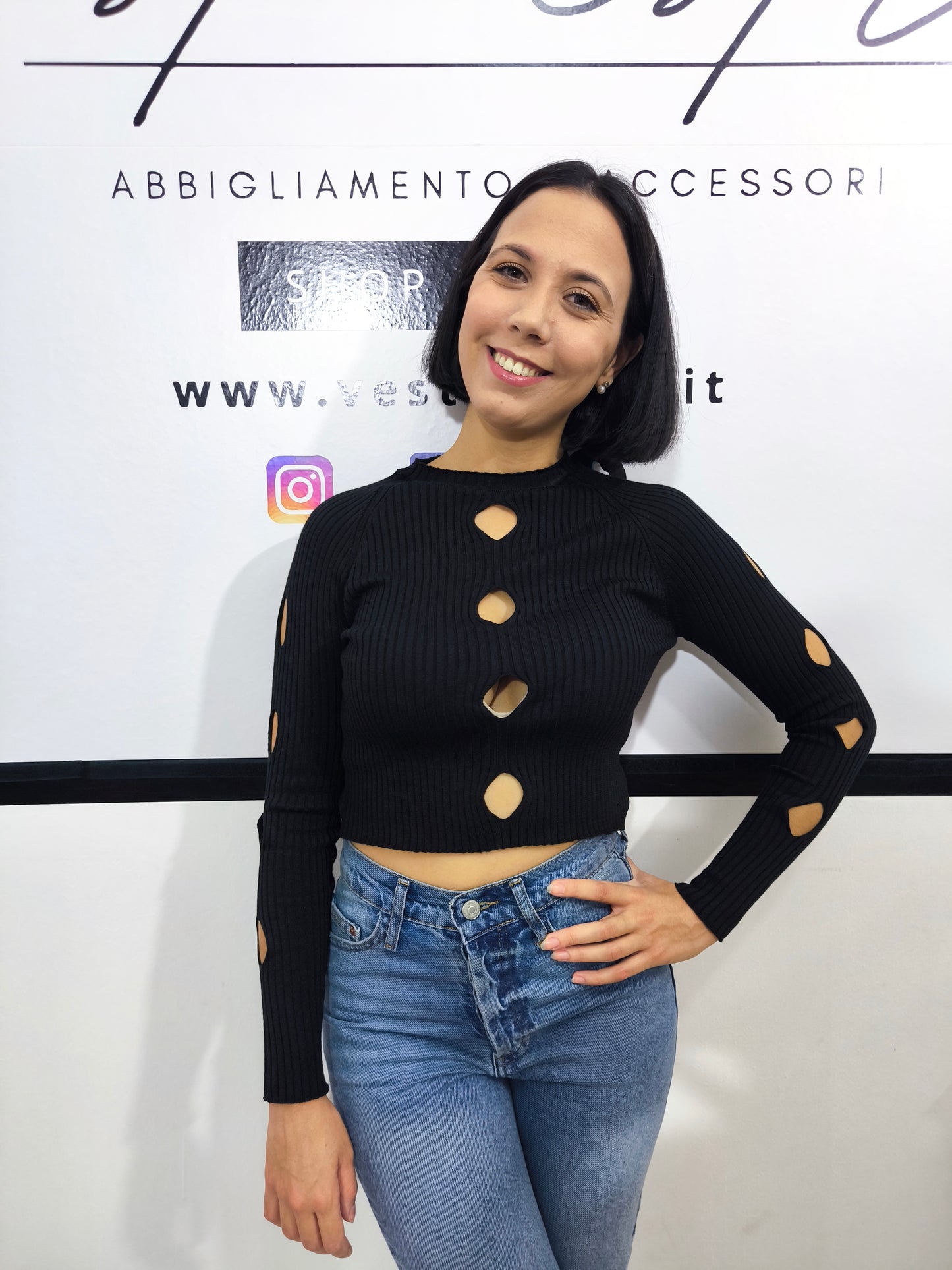 Maglia nera a costine da donna con dettagli cut-out sul davanti.