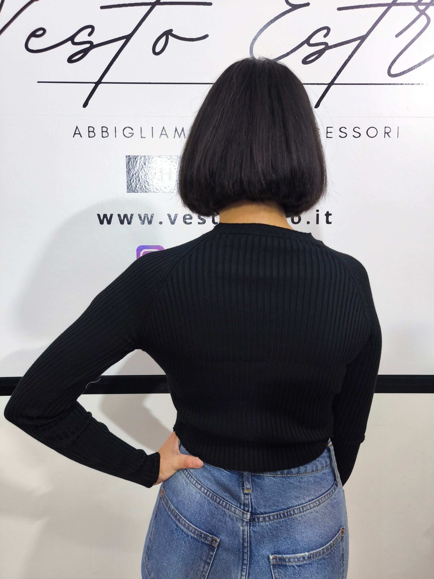 Maglia nera a costine da donna con dettagli cut-out sul davanti.