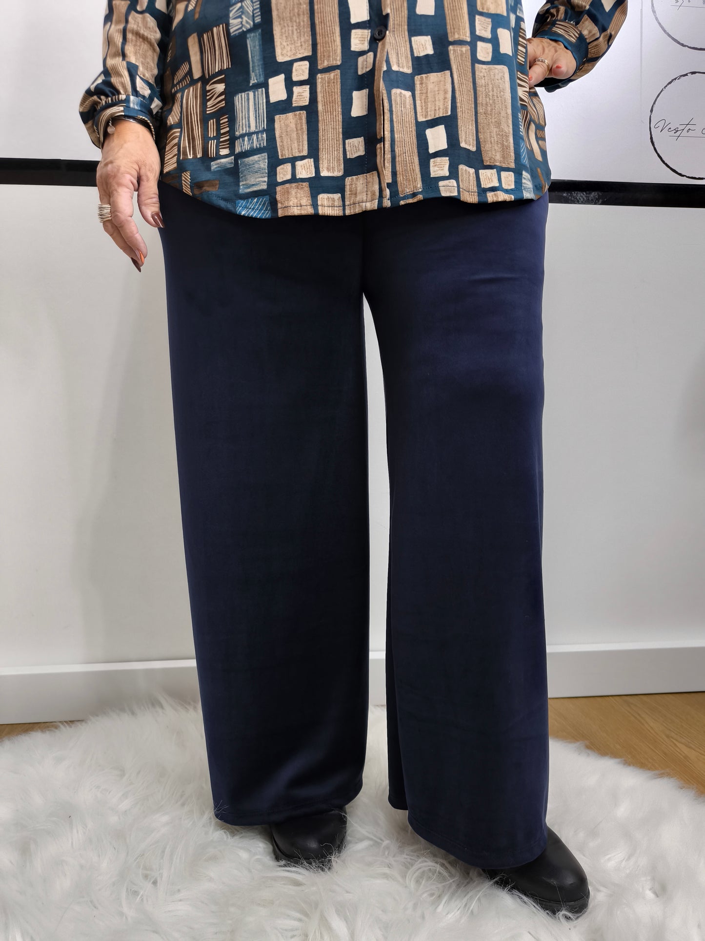 Pantaloni a palazzo blu in tessuto morbido, indossati da una donna per un look elegante e versatile.
