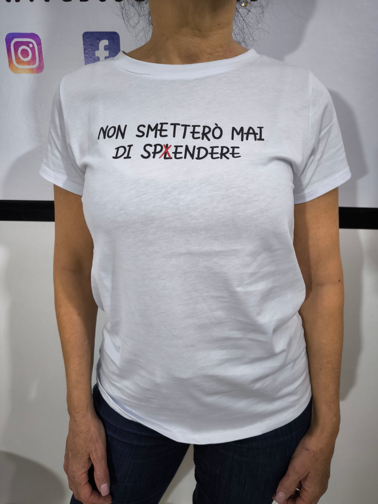 Donna che indossa t-shirt bianca con scritta "Non smetterò mai di spLendere" su un jeans