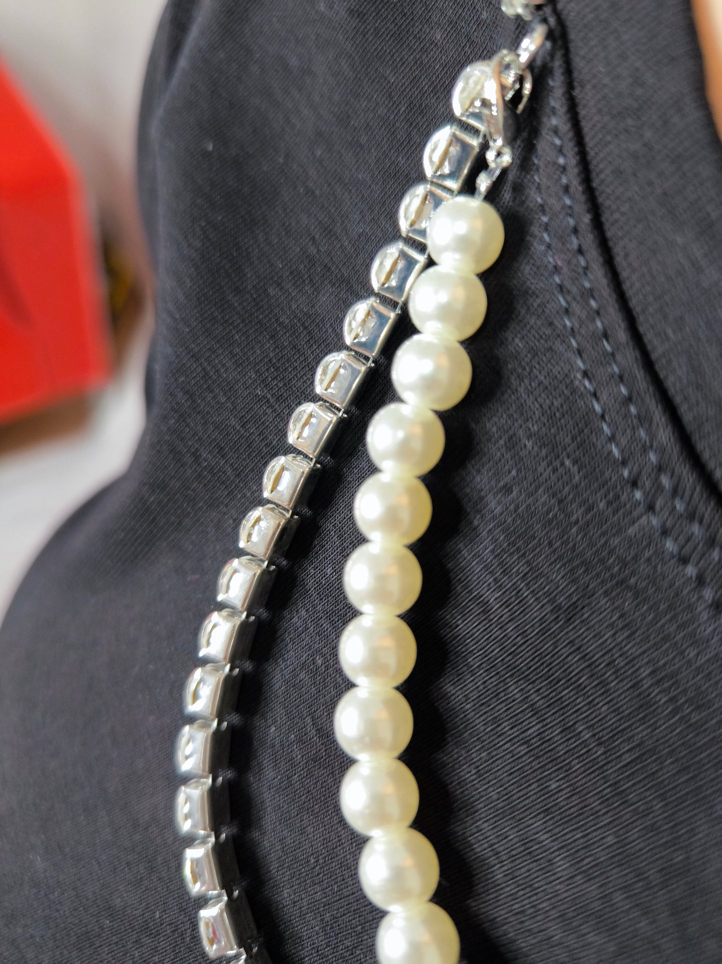 T-shirt nera da donna con girocollo decorato da collana di perle e strass, elegante e versatile per look casual chic.