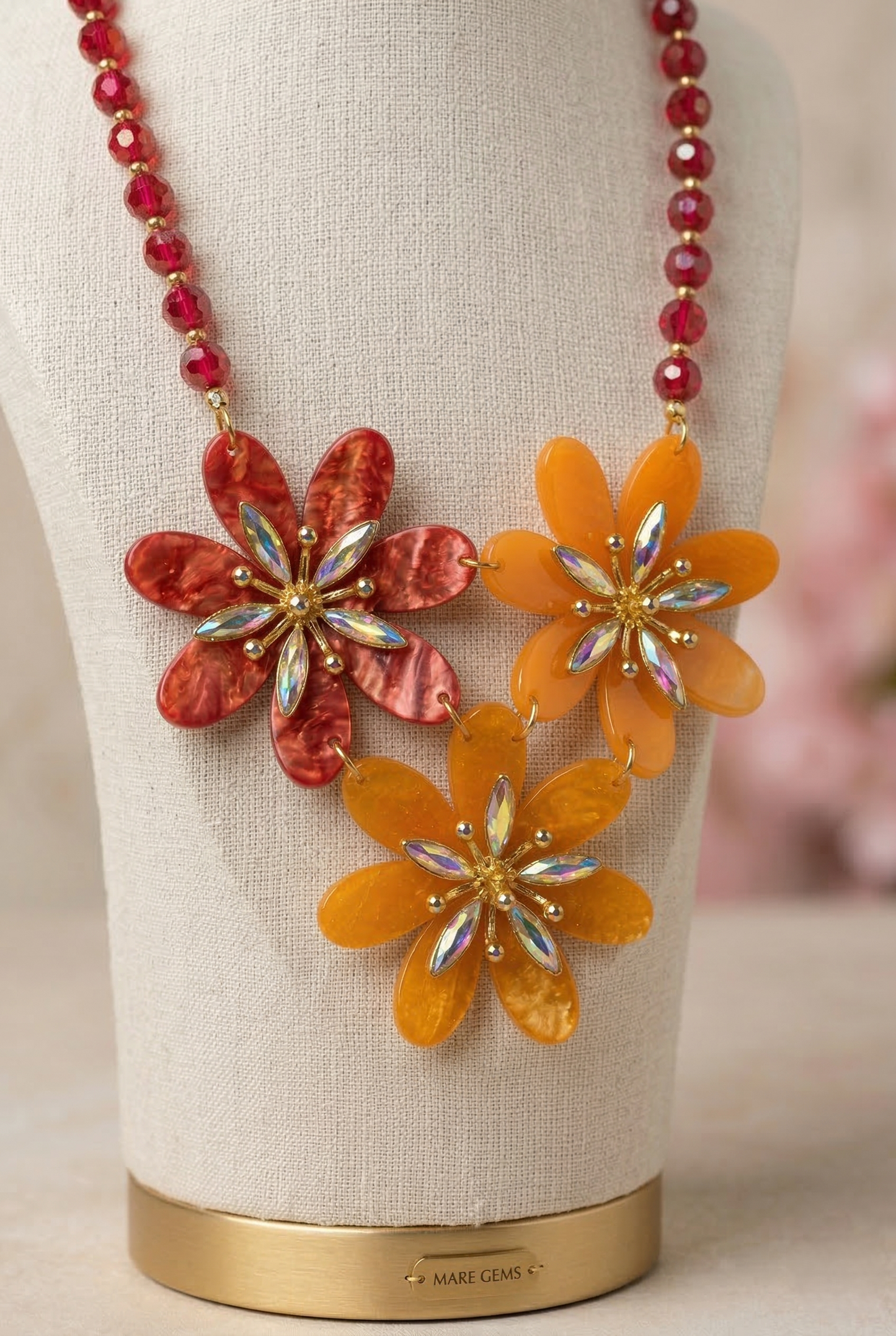 Dettaglio collana floreale elegante con cristalli iridescenti e perline rosse