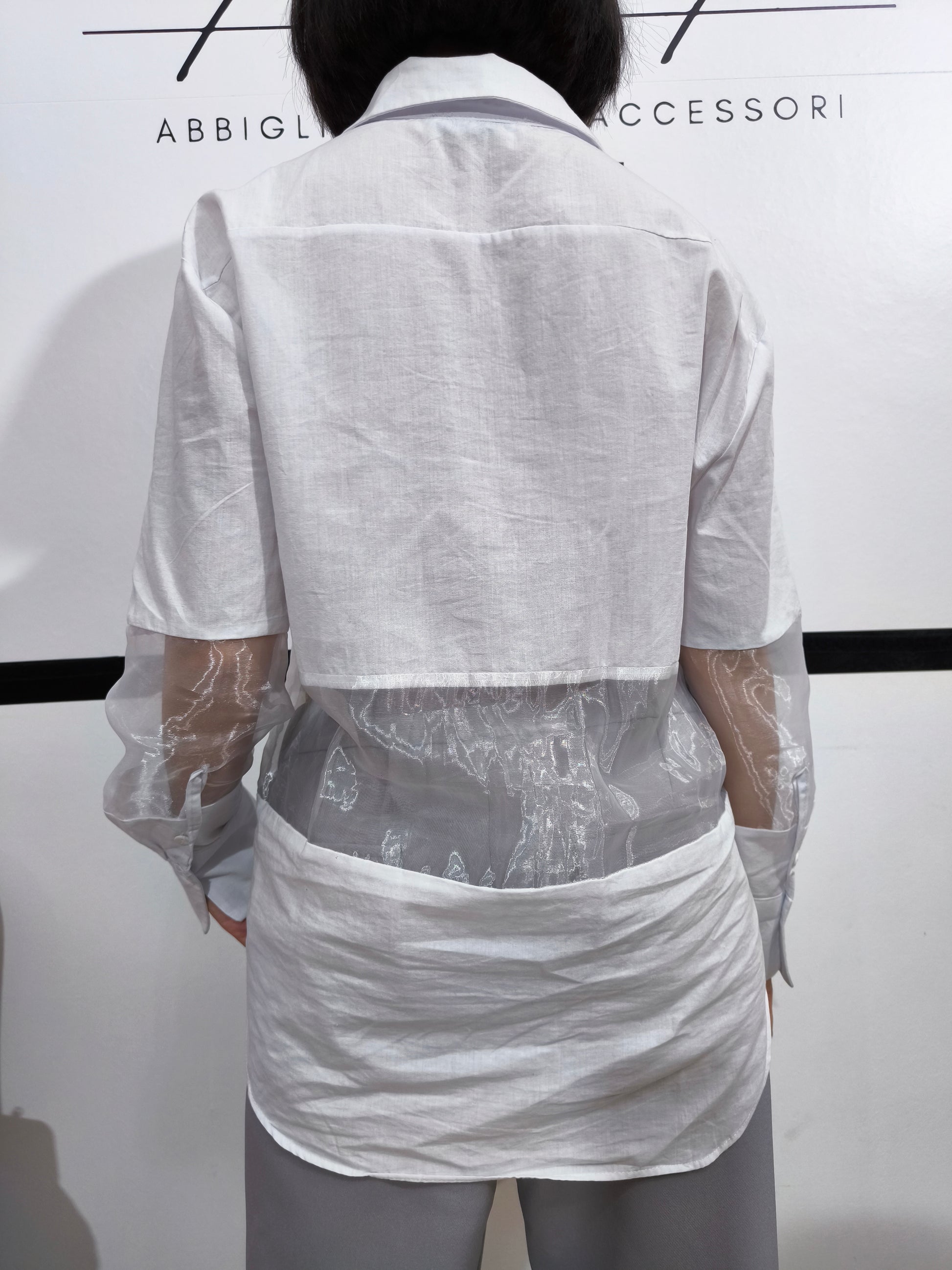 Camicia bianca con pannelli trasparenti in tulle, perfetta per un look moderno e femminile, con maniche lunghe e design elegante.