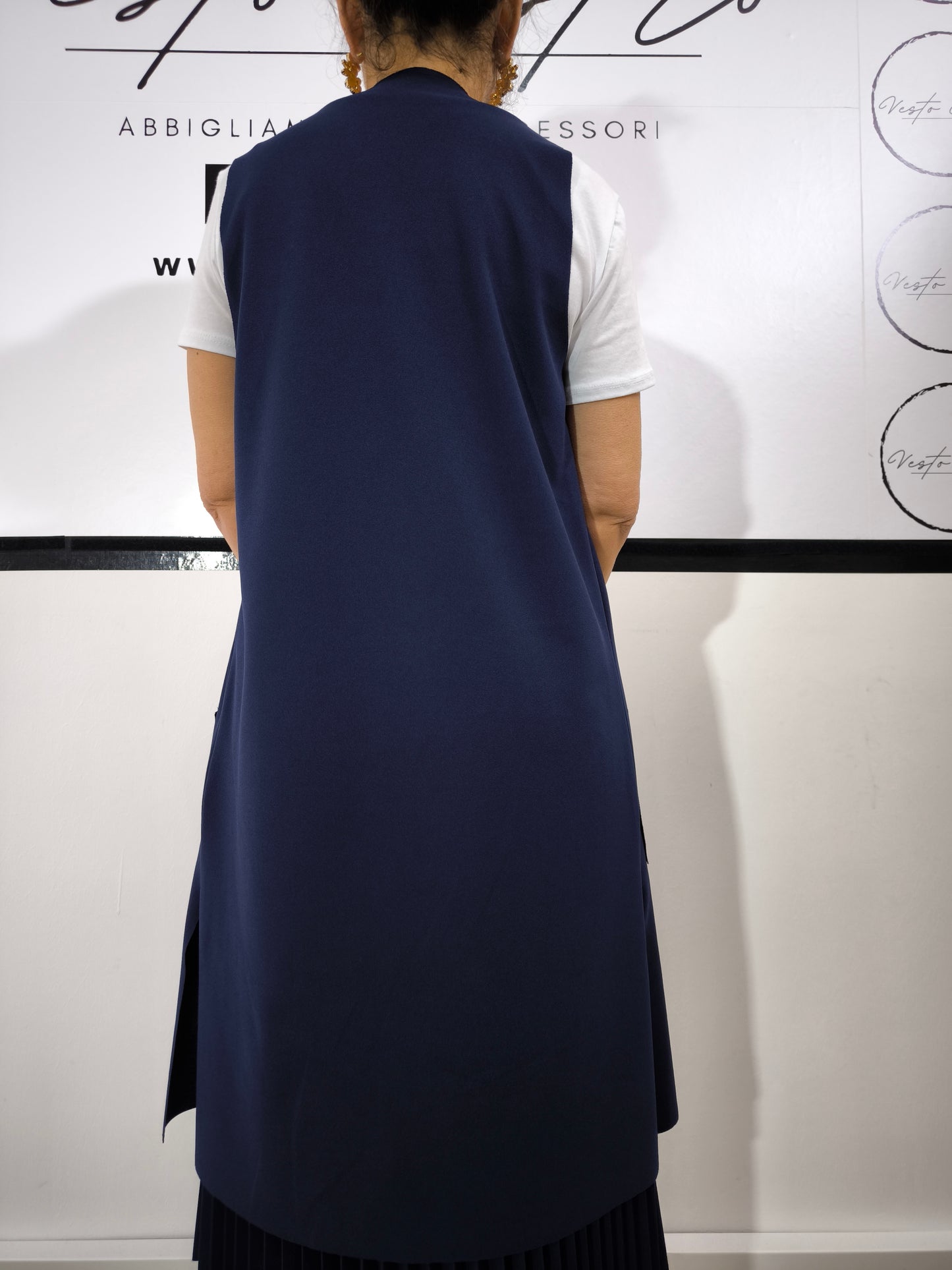 Completo donna con gilet lungo blu e t-shirt bianca, abbinato a gonna plissettata, perfetto per un look casual elegante.