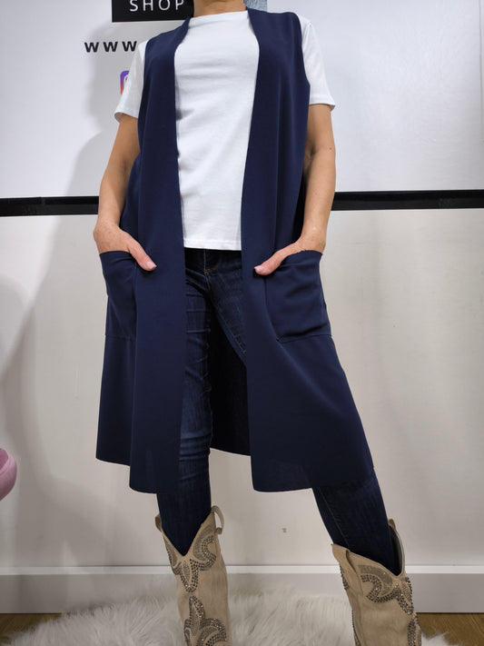 Completo donna con gilet lungo blu e t-shirt bianca, abbinato a jeans skinny, perfetto per un look casual elegante.