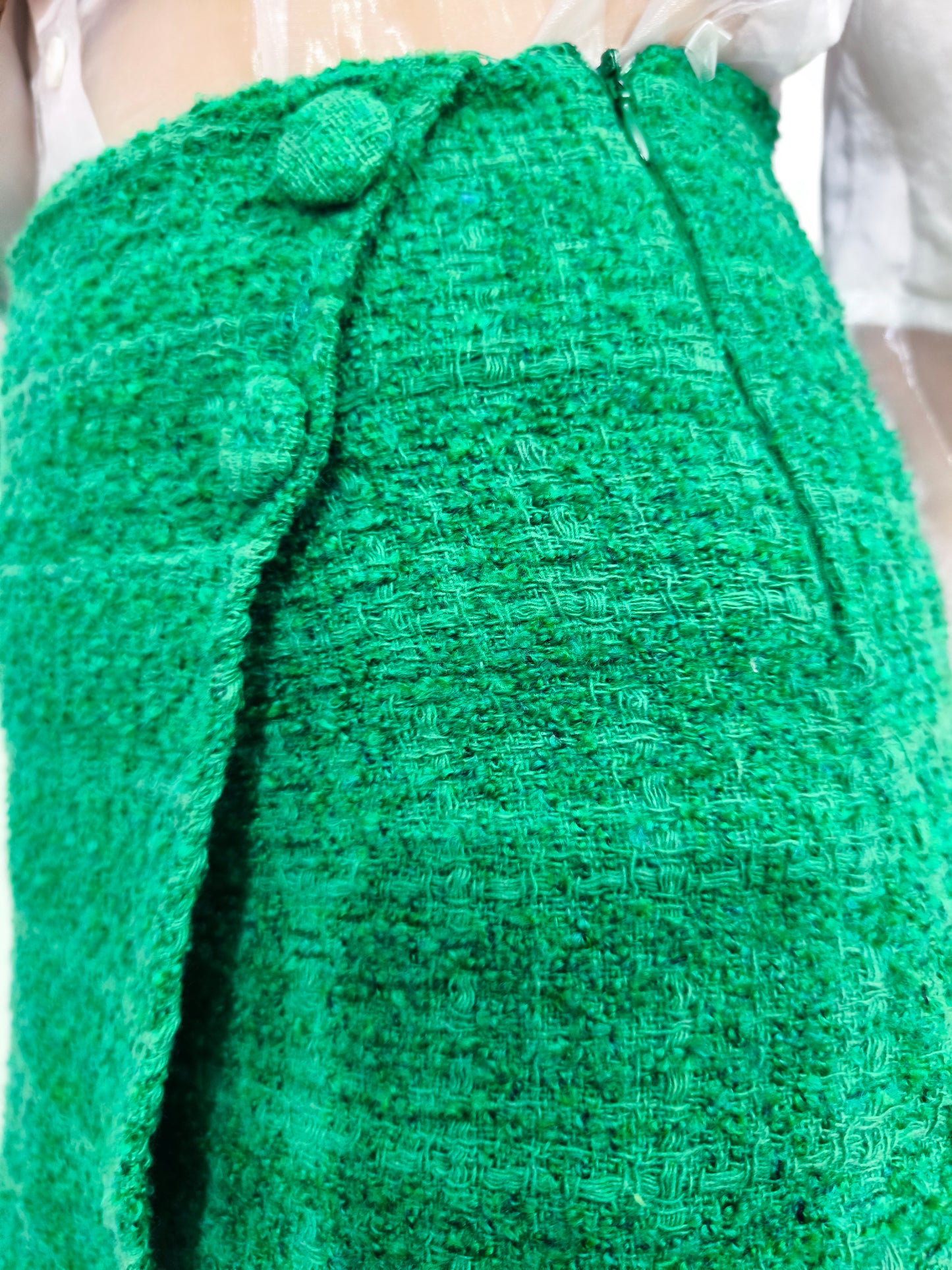 Gonna pantaloncino corta in tessuto tweed verde con dettaglio a bottoni e design avvolgente, perfetta per un look casual chic ed elegante.