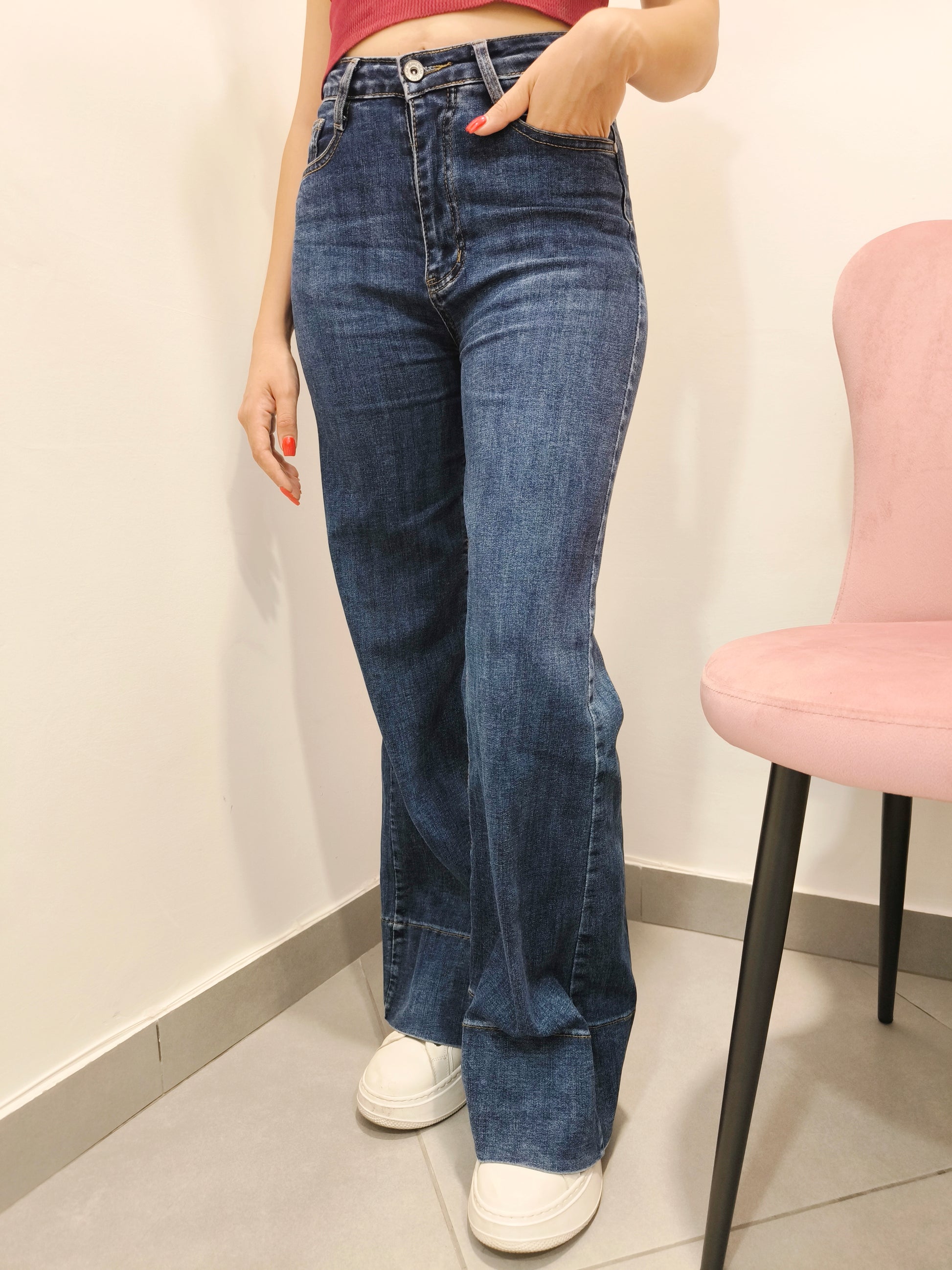jeans donna a zampa in denim blu vita alta con sneakers bianche