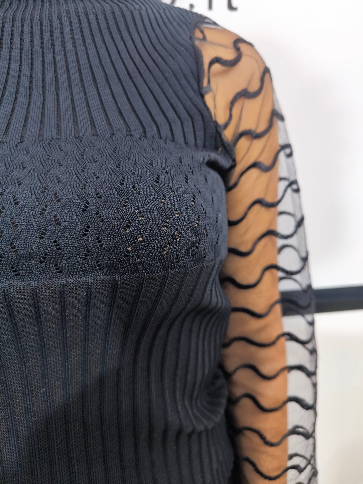 Maglia nera a collo alto con maniche trasparenti in tulle ondulato, abbigliamento elegante donna, perfetto per look casual o formali