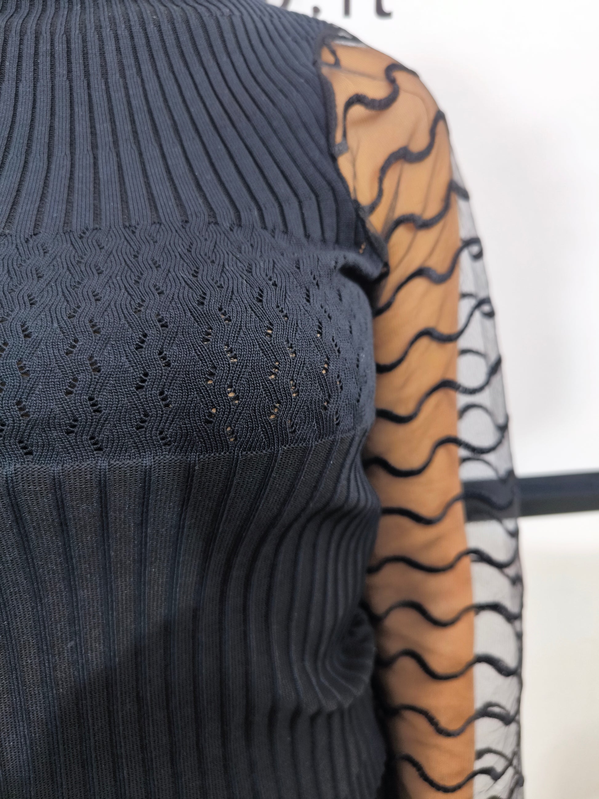 Maglia nera a collo alto con maniche trasparenti in tulle ondulato, abbigliamento elegante donna, perfetto per look casual o formali