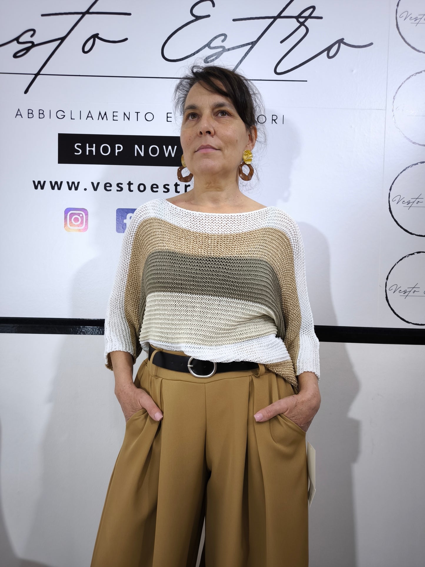 Maglione a righe da donna in maglia larga con colori sabbia, beige e bianco, abbinato a pantaloni palazzo per un look casual-chic.
