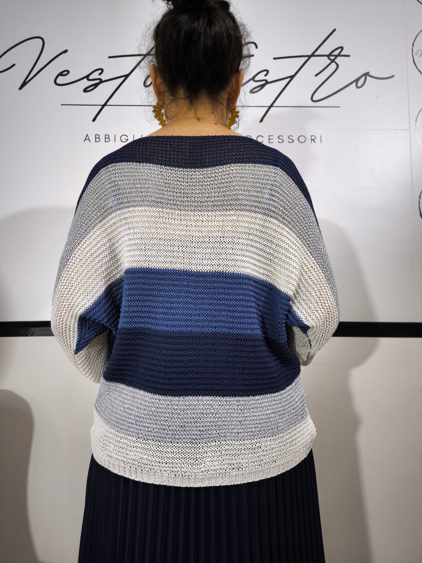 Maglione a righe da donna in maglia larga con colori blu, bianco e argento abbinato a pantaloni palazzo per un look casual-chic.