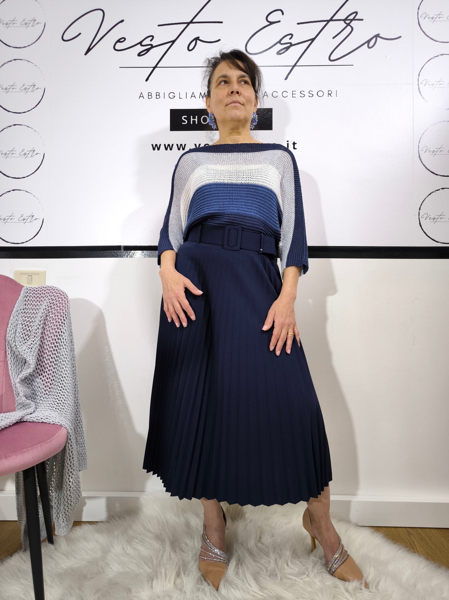 Maglione a righe da donna in maglia larga con colori blu, bianco e argento abbinato a pantaloni palazzo per un look casual-chic.