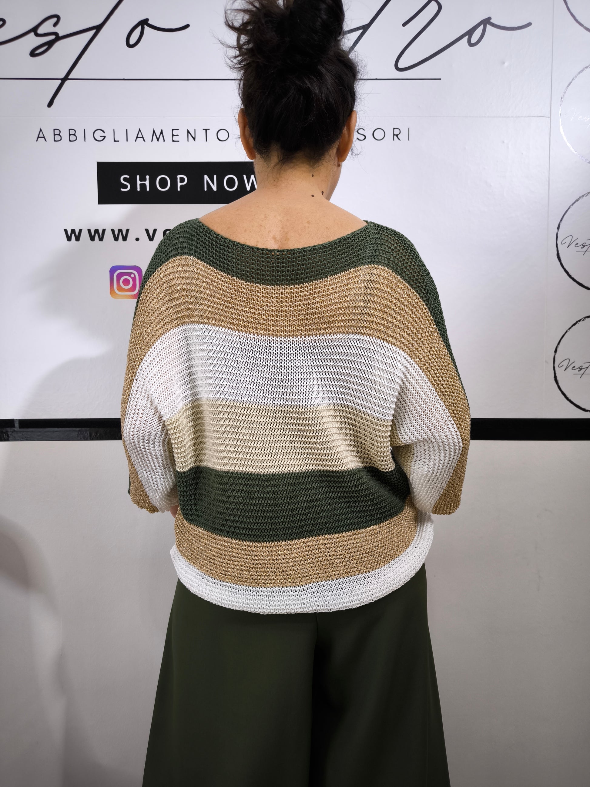 Maglione a righe da donna in maglia larga con colori verde militare, beige e bianco, abbinato a pantaloni palazzo per un look casual-chic.