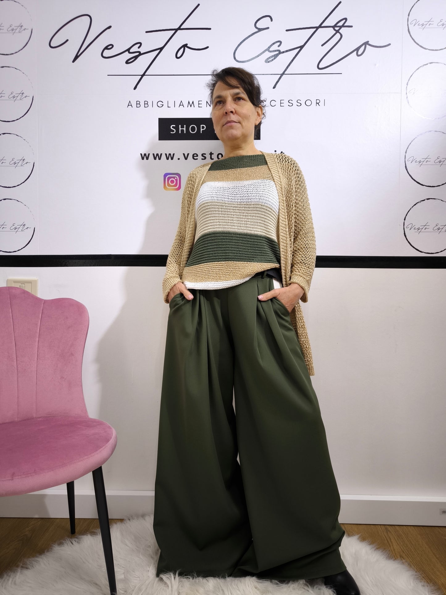Maglione a righe da donna in maglia larga con colori verde militare, beige e bianco, abbinato a pantaloni palazzo per un look casual-chic.