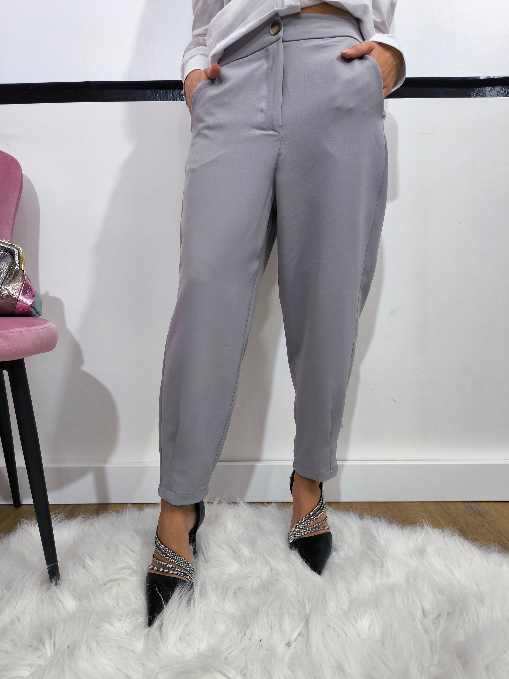 Pantalone grigio con tasche posteriori a patta, vestibilità dritta e chiusura con bottone e cerniera, ideale per un look casual chic o formale.