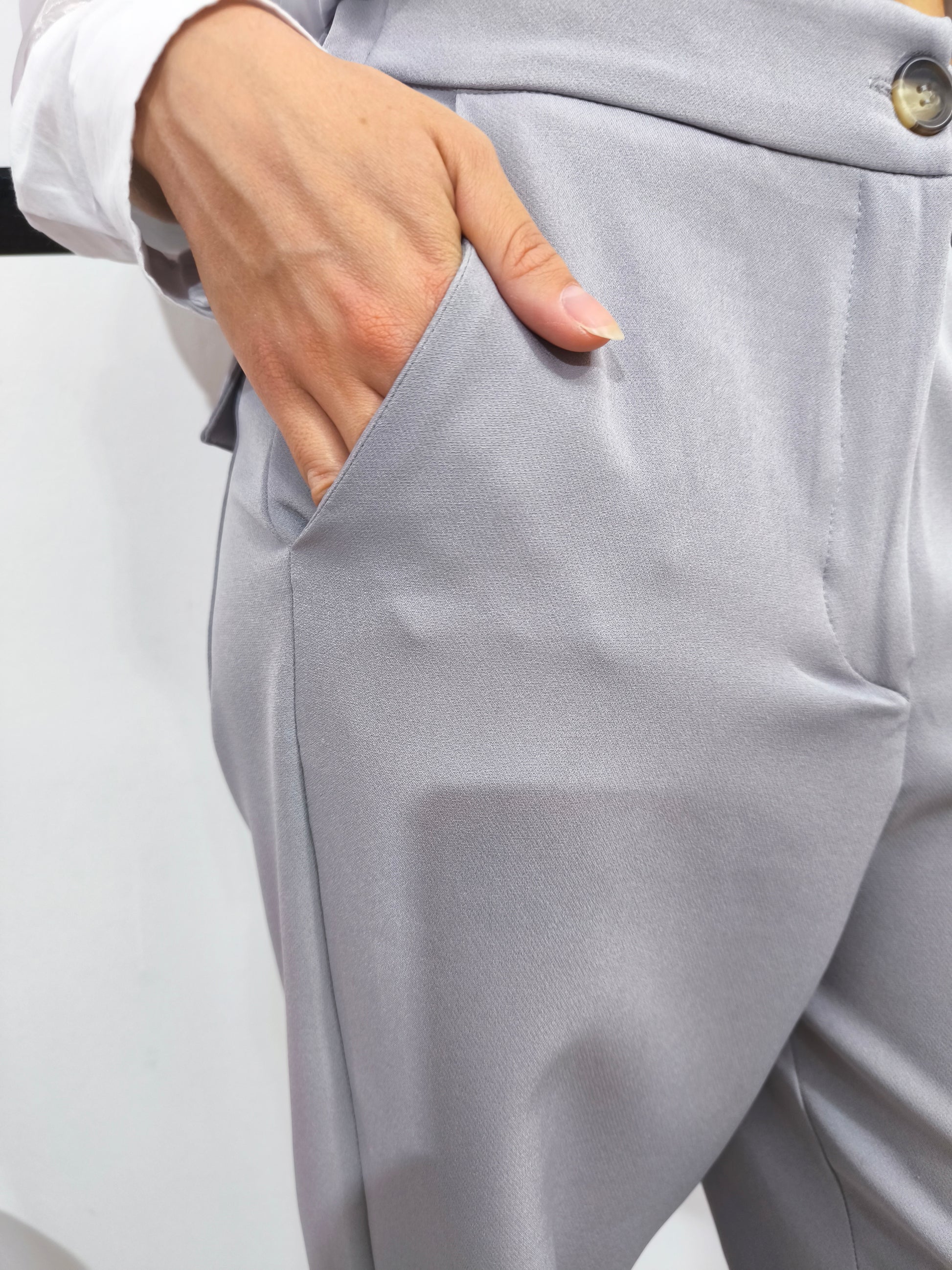 Pantalone grigio con tasche posteriori a patta, vestibilità dritta e chiusura con bottone e cerniera, ideale per un look casual chic o formale.