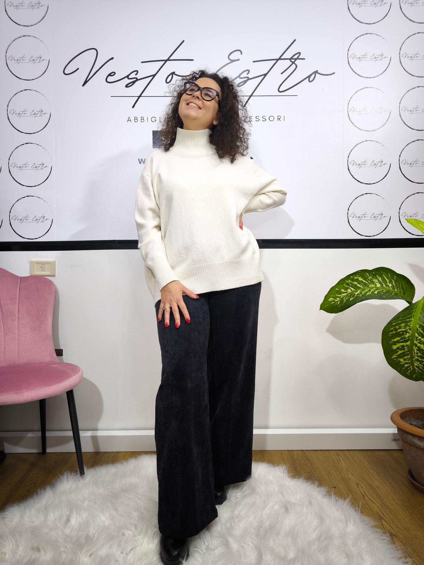 Pantalone in velluto a costine nero con taglio a palazzo indossato da donna con maglione bianco.