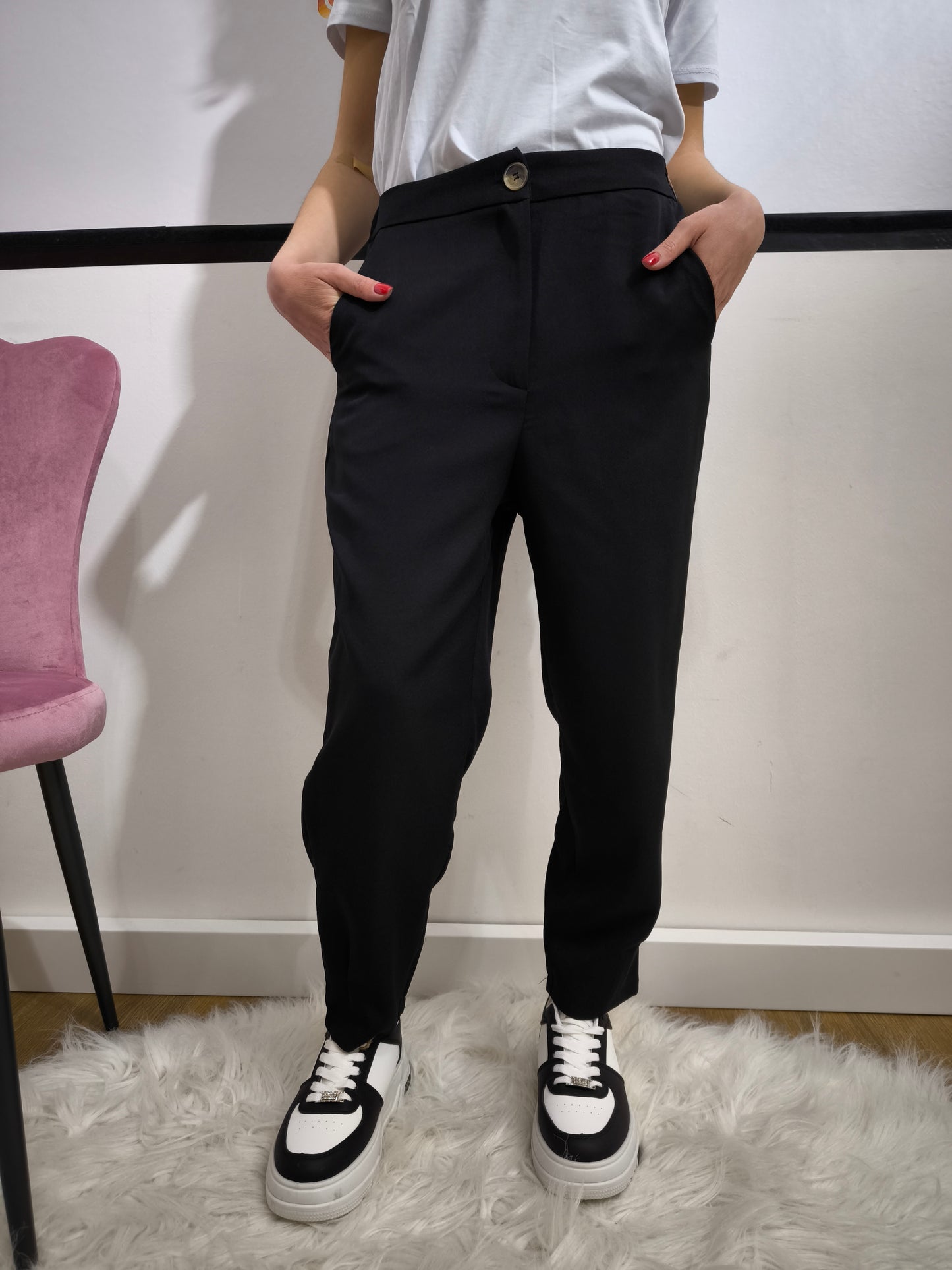 Pantalone nero con tasche posteriori a patta, vestibilità dritta e chiusura con bottone e cerniera, ideale per un look casual chic o formale.