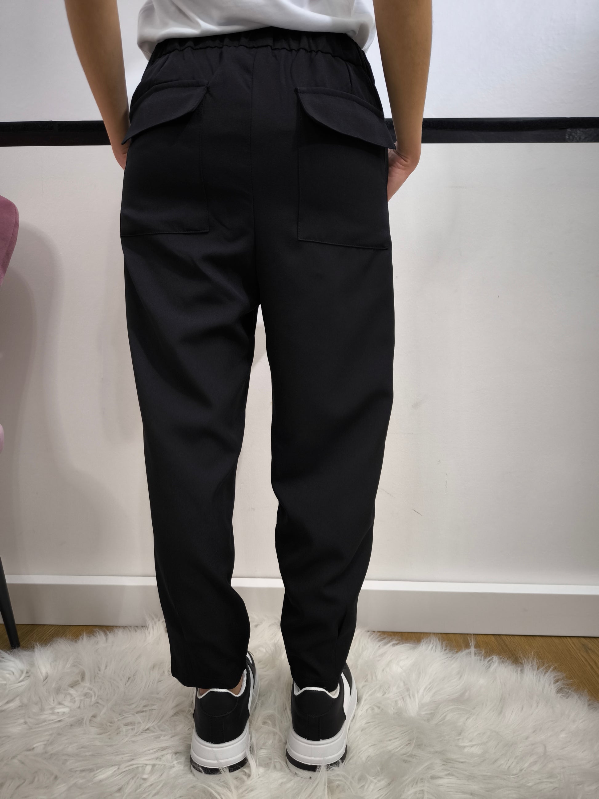 Pantalone nero con tasche posteriori a patta, vestibilità dritta e chiusura con bottone e cerniera, ideale per un look casual chic o formale.