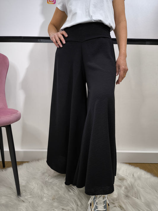Pantaloni casual larghi e morbidi, con fascia alta e tessuto leggero abbinato a una t-shirt e sneakers