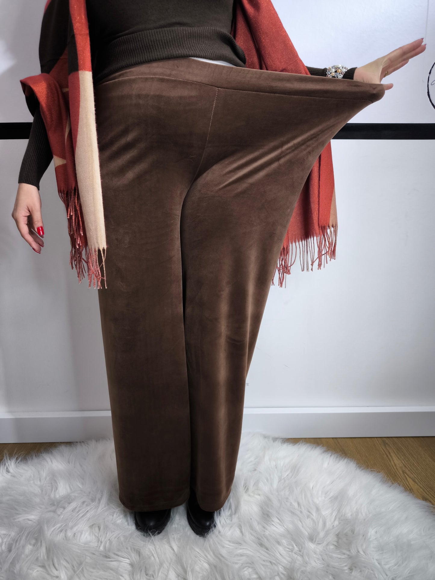 Pantaloni a palazzo marroni in tessuto morbido, indossati da una donna per un look elegante e versatile.
