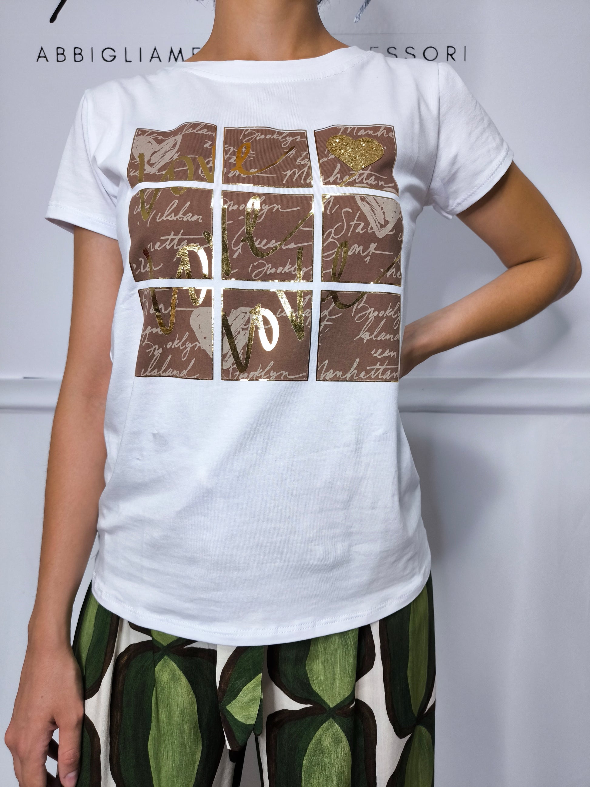 T-shirt bianca e marrone con scritte decorative e dettagli dorati