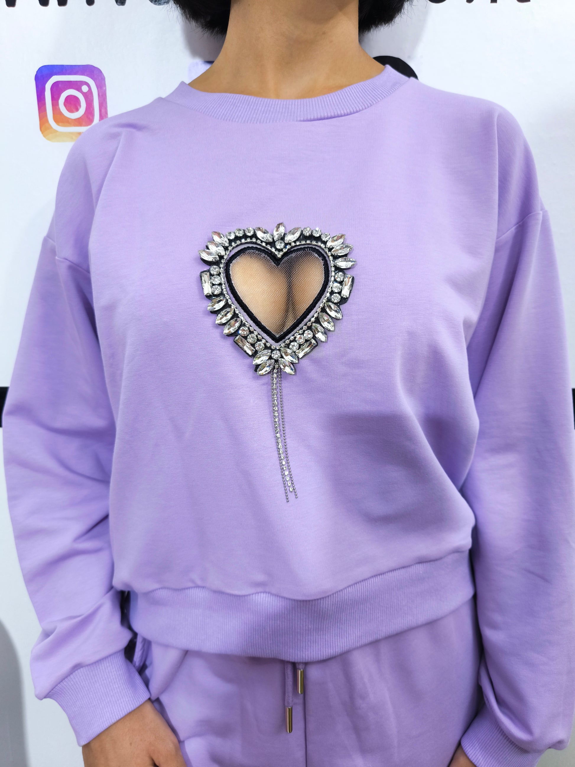 Tuta in cotone organico da donna, composta da felpa e pantaloni con applicazioni cuore gioiello, look casual e glamour.