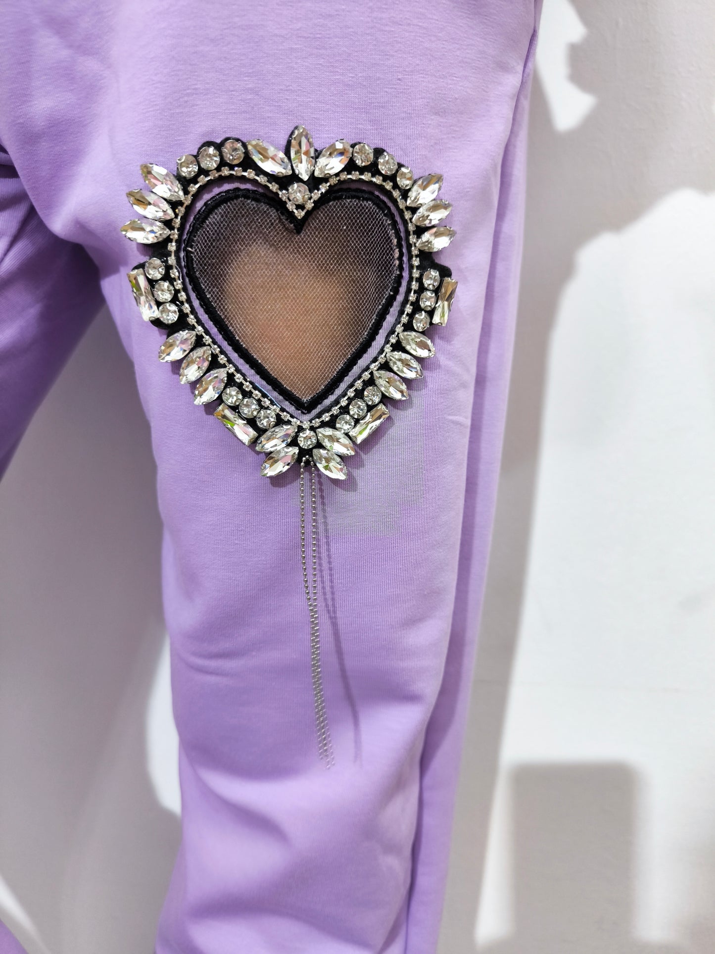 Tuta in cotone organico da donna, composta da felpa e pantaloni con applicazioni cuore gioiello, look casual e glamour.