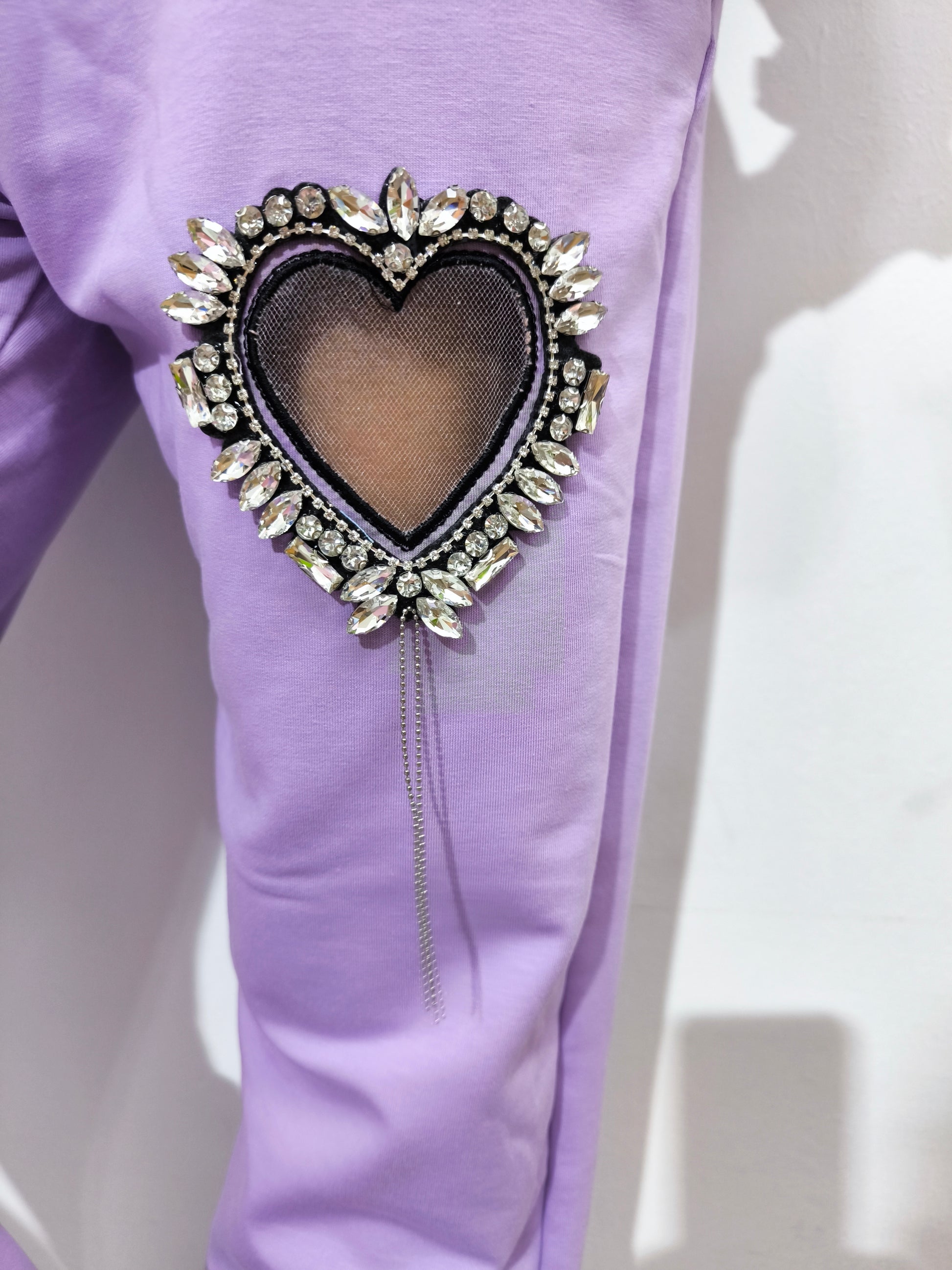 Tuta in cotone organico da donna, composta da felpa e pantaloni con applicazioni cuore gioiello, look casual e glamour.