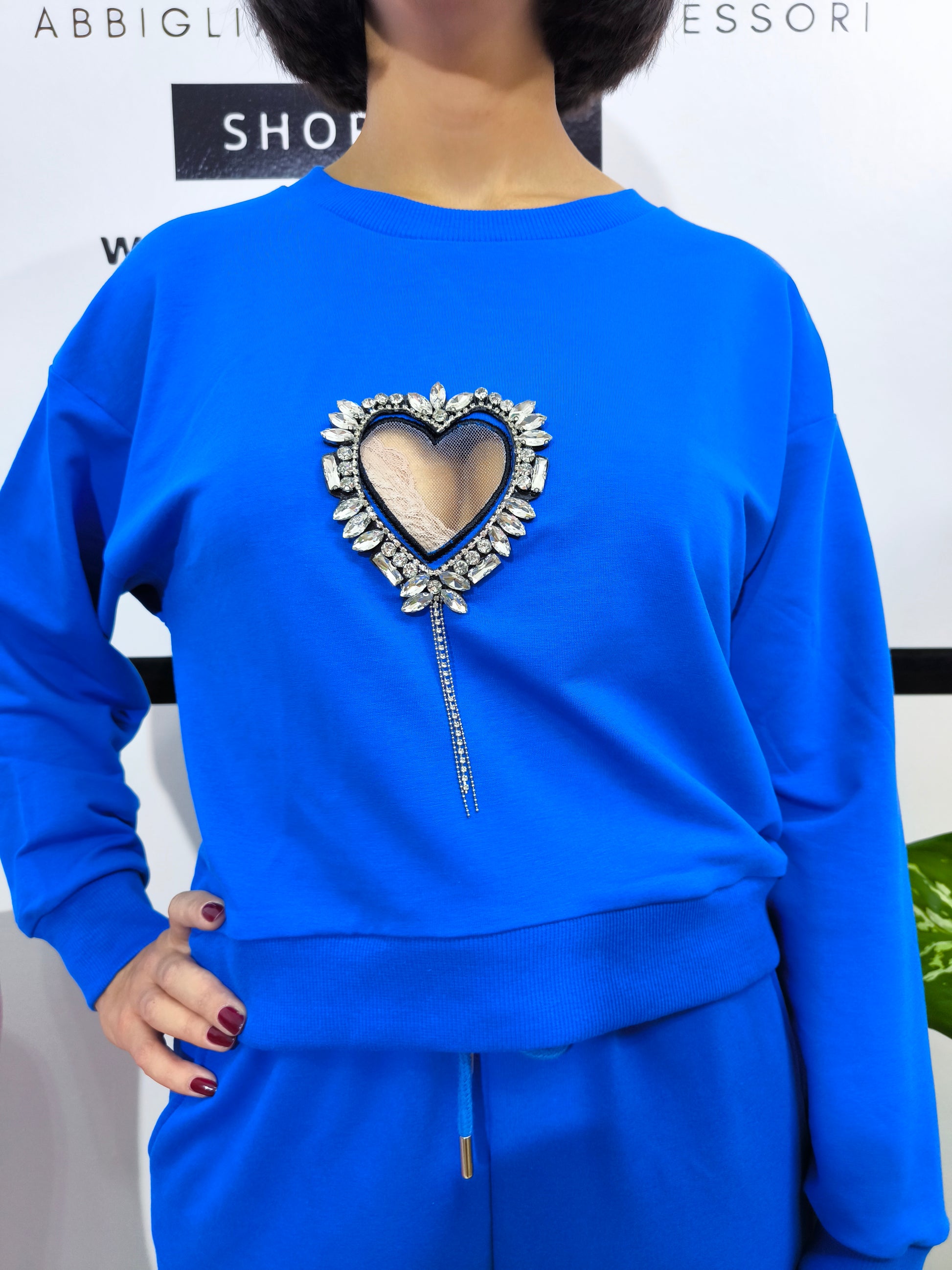 Tuta in cotone organico da donna, composta da felpa e pantaloni con applicazioni cuore gioiello, look casual e glamour.