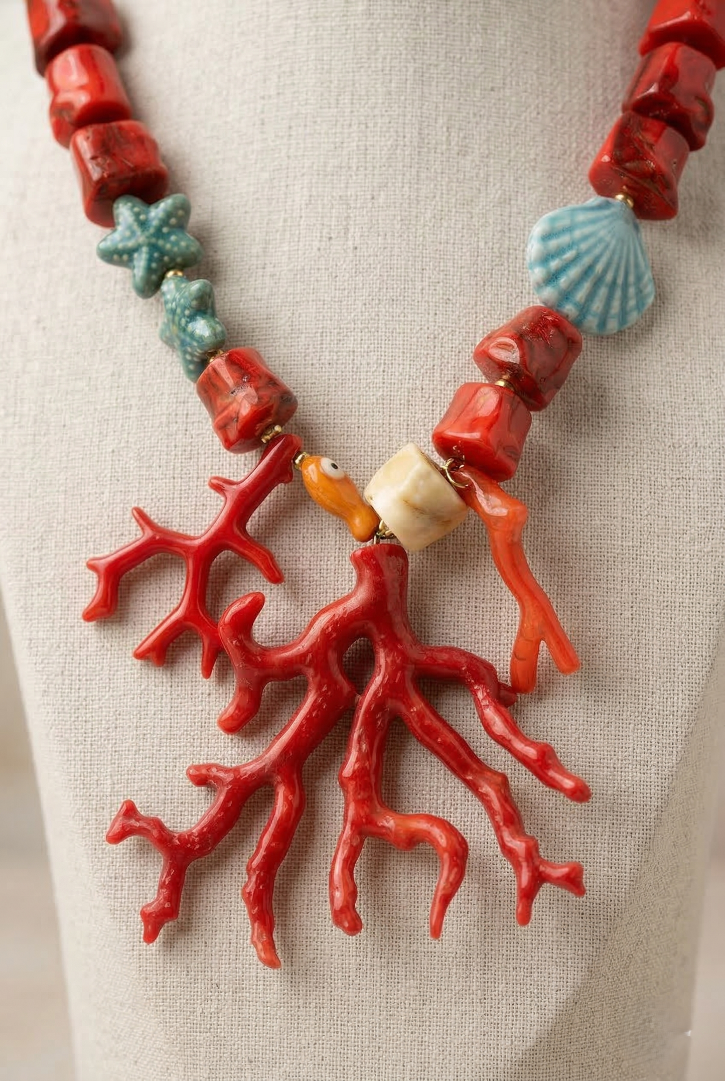 Collana statement ispirata al mare con corallo rosso, conchiglia e stelle marine