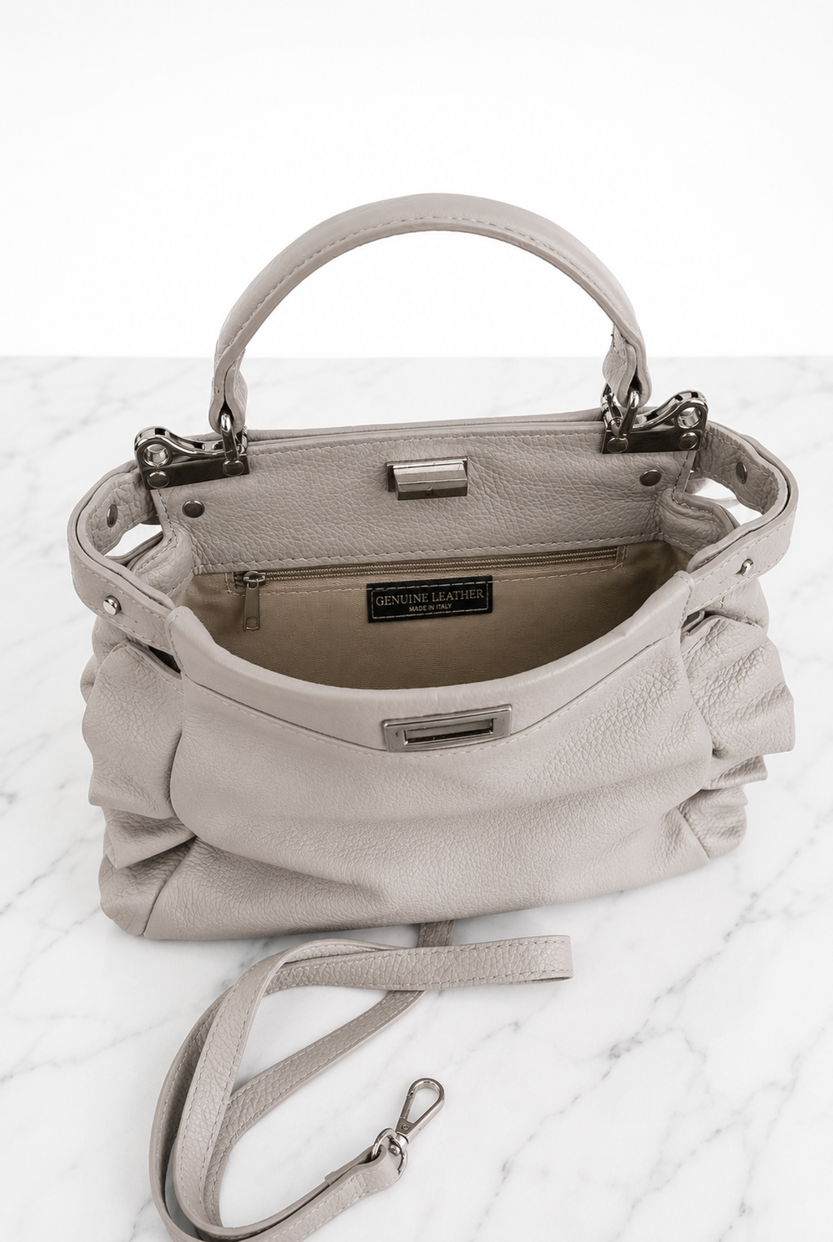 Interno foderato della borsa in vera pelle grigio perla con tasca dotata di zip