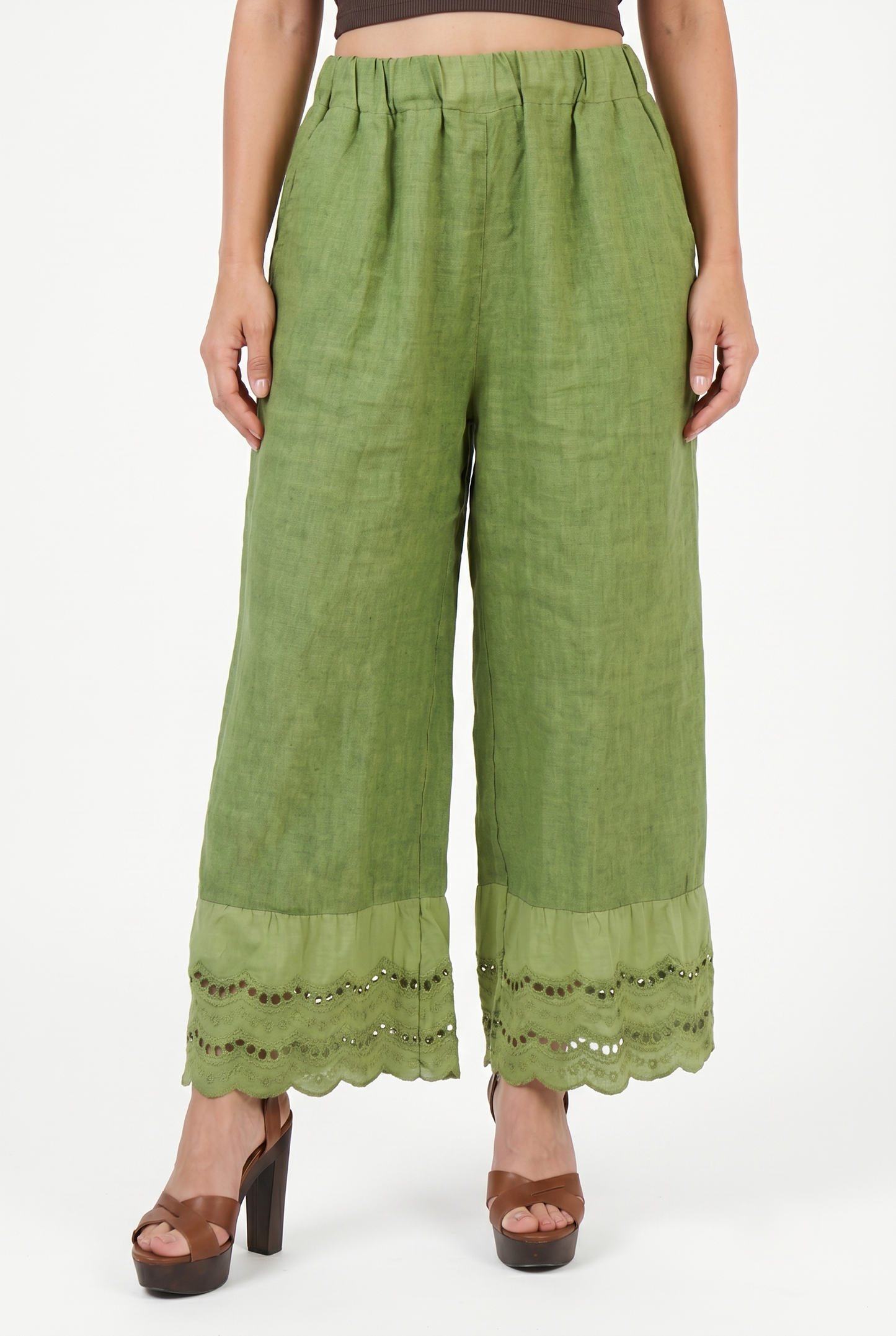 Dettaglio frontale dei pantaloni palazzo in puro lino verde con vita elasticizzata e bordo ricamato.