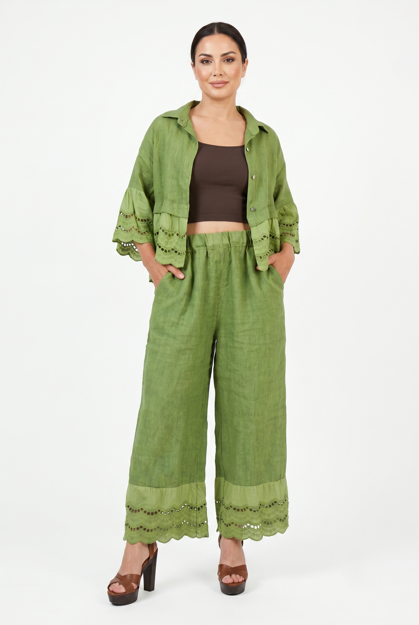 Modella con pantaloni palazzo in puro lino verde e camicia coordinata con dettagli sangallo.