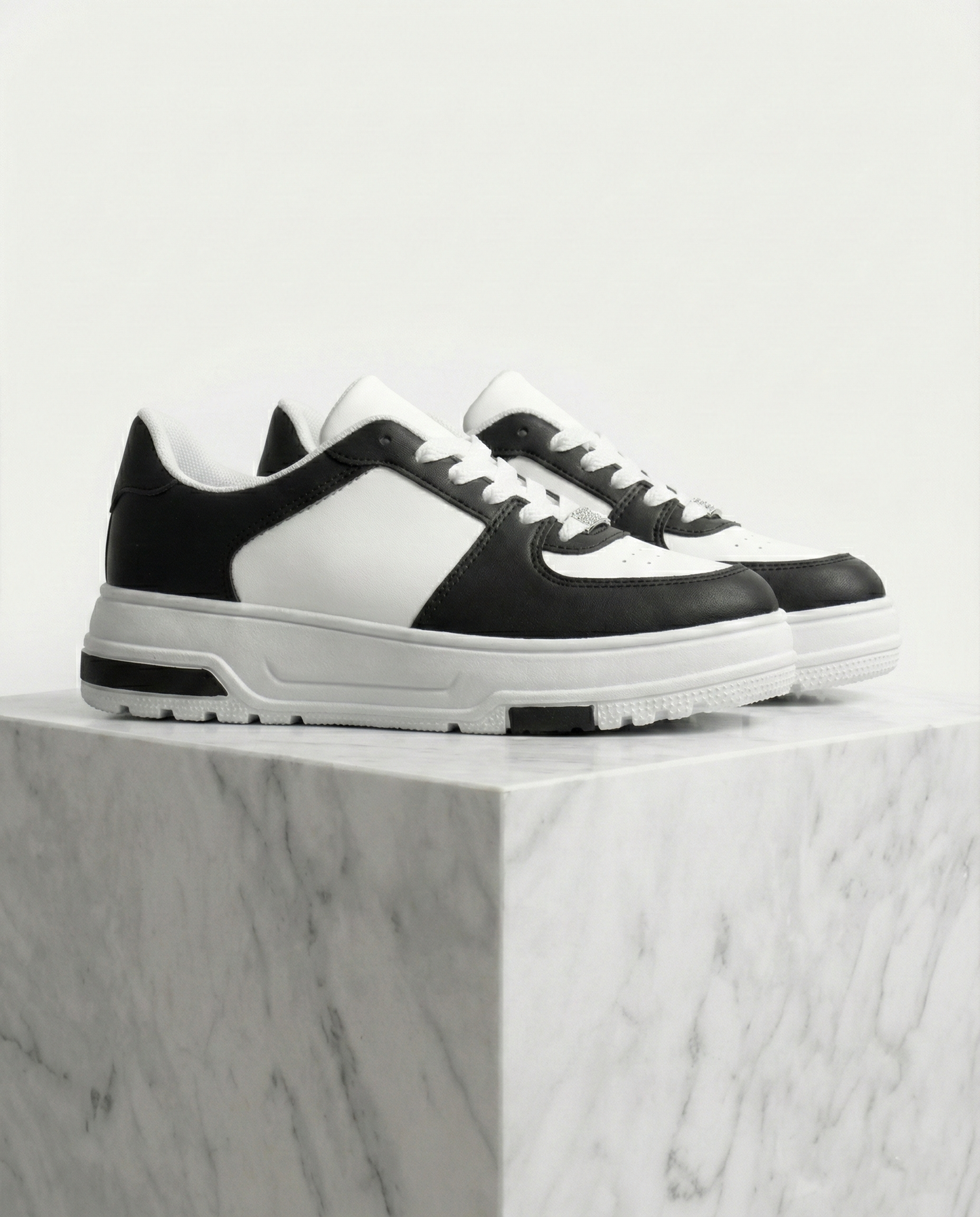 Sneakers donna casual bianco e nero vista laterale su base marmo