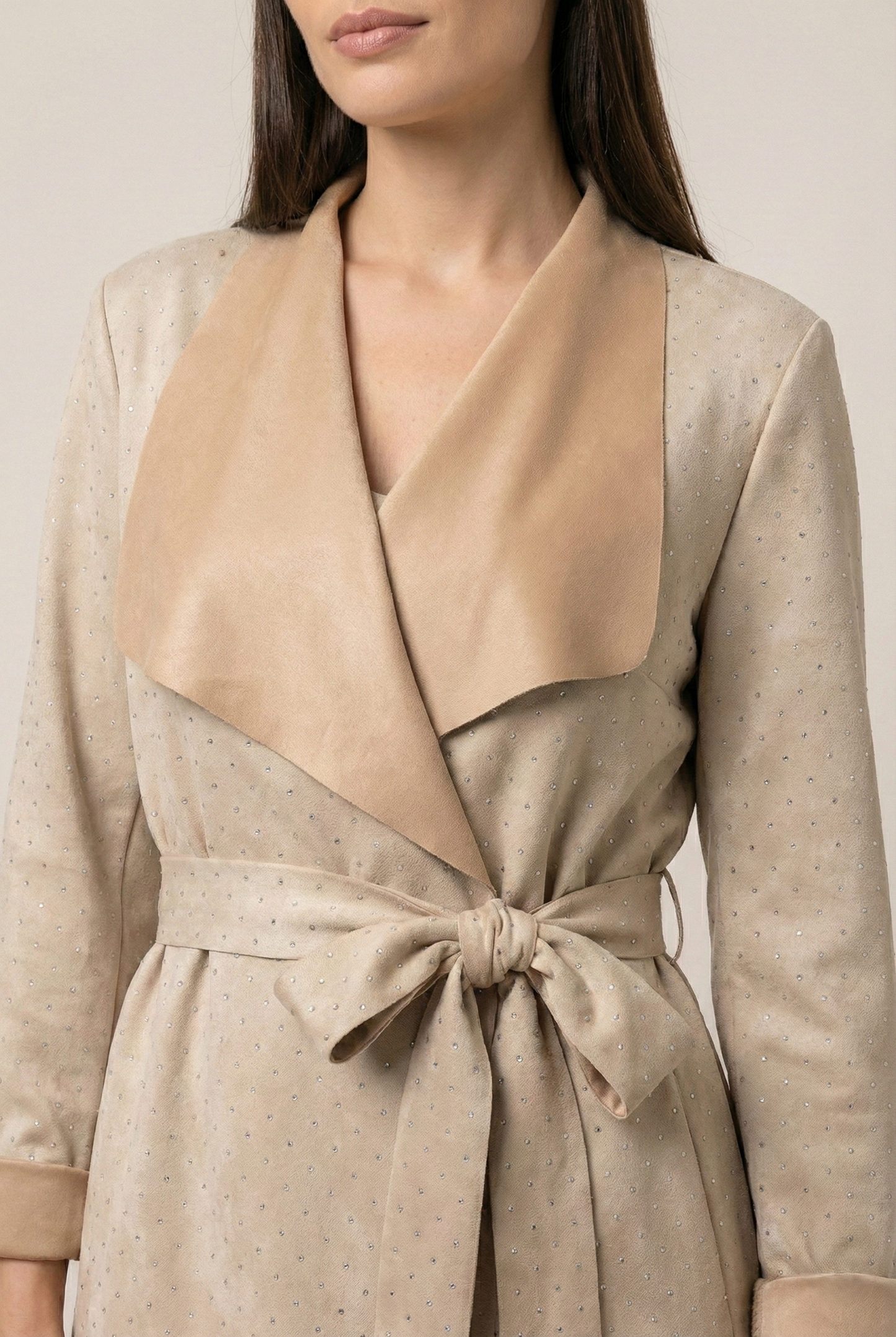 Dettaglio spolverino donna beige effetto scamosciato con punti luce e cinta in vita elegante mezza stagione